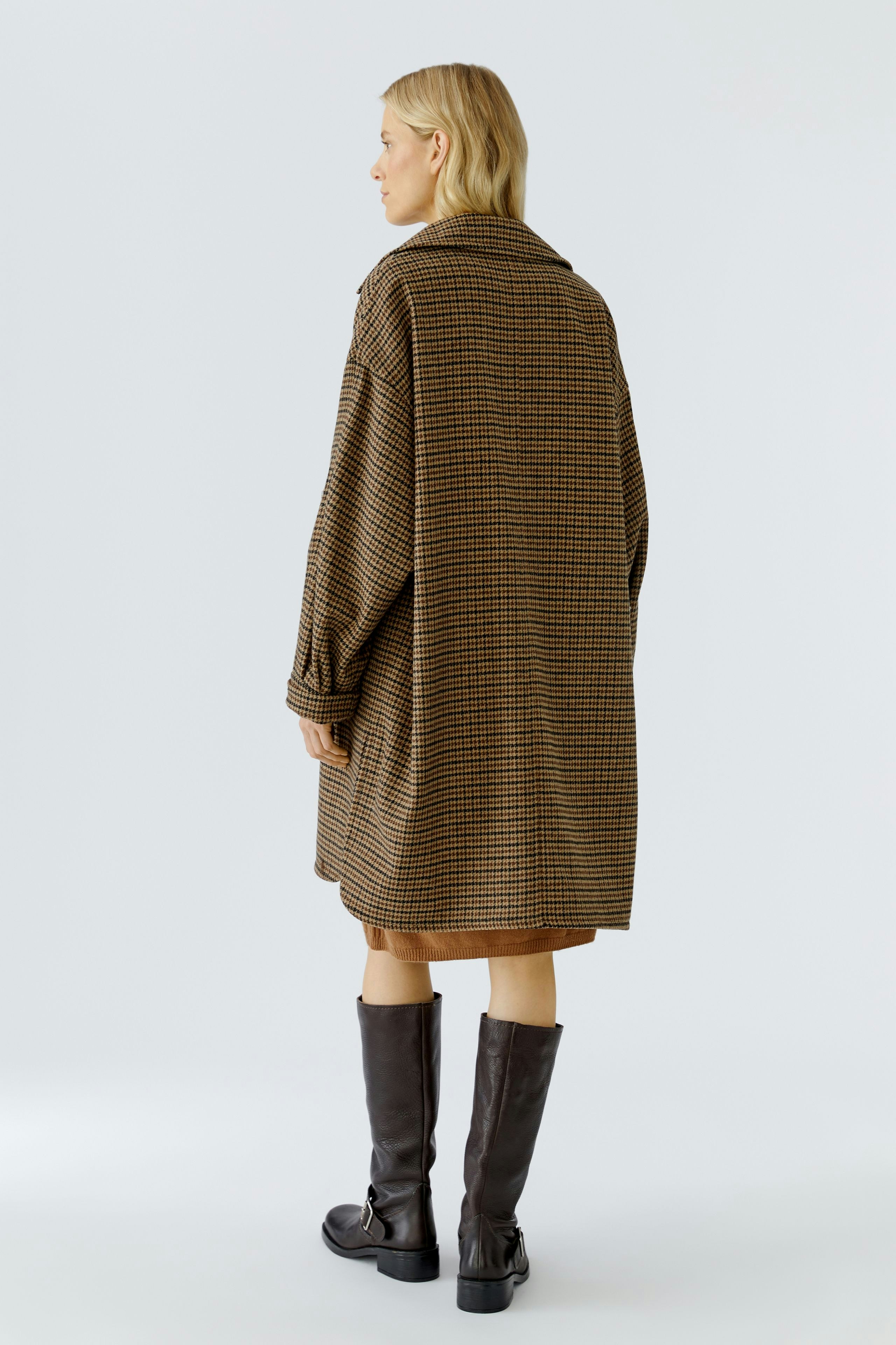 Stylish women's wool coat: A woman in a brown striped coat stands confidently, showcasing a relaxed fit.
