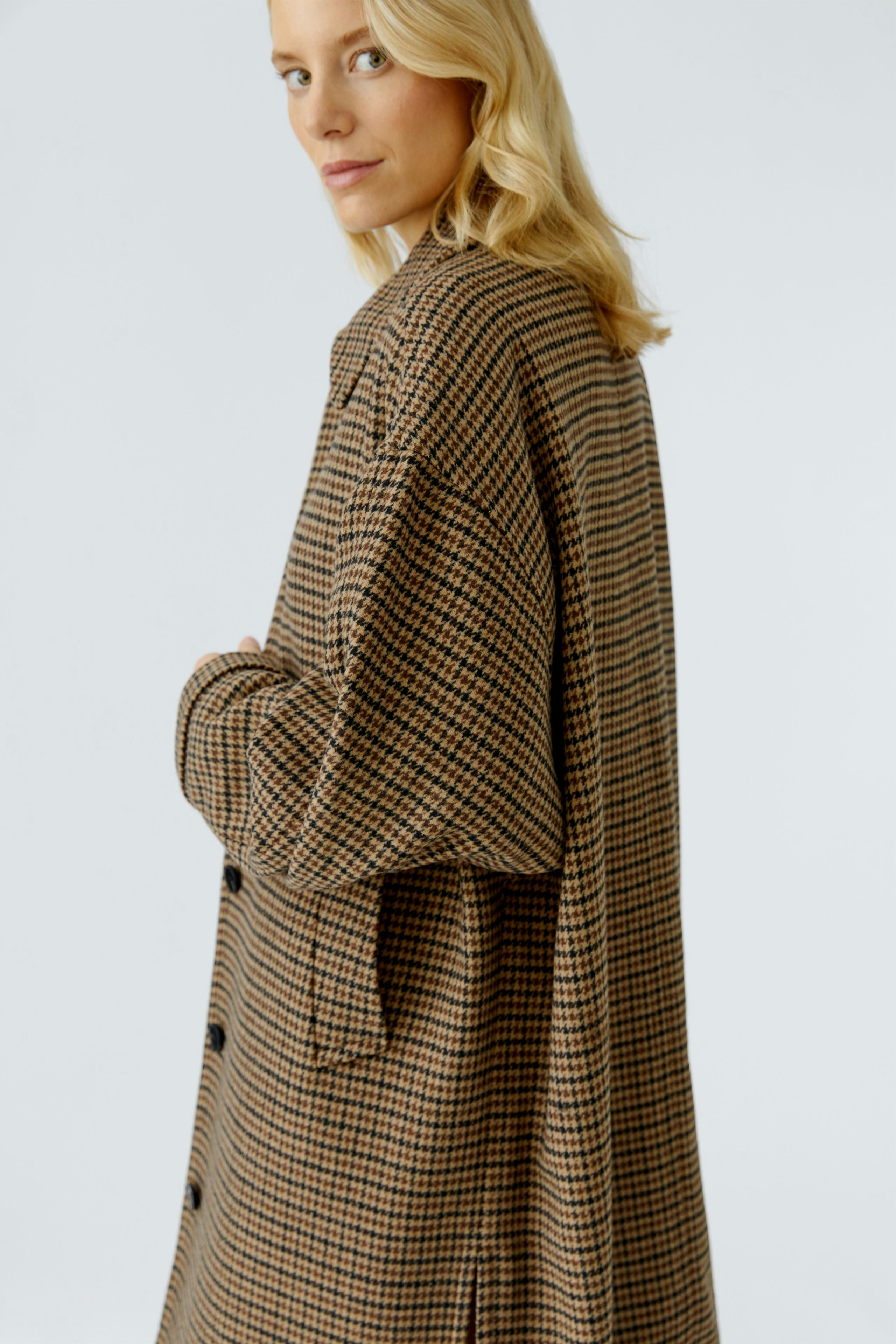 Casual women's wool coat: A woman in a brown checkered wool coat with a relaxed fit.