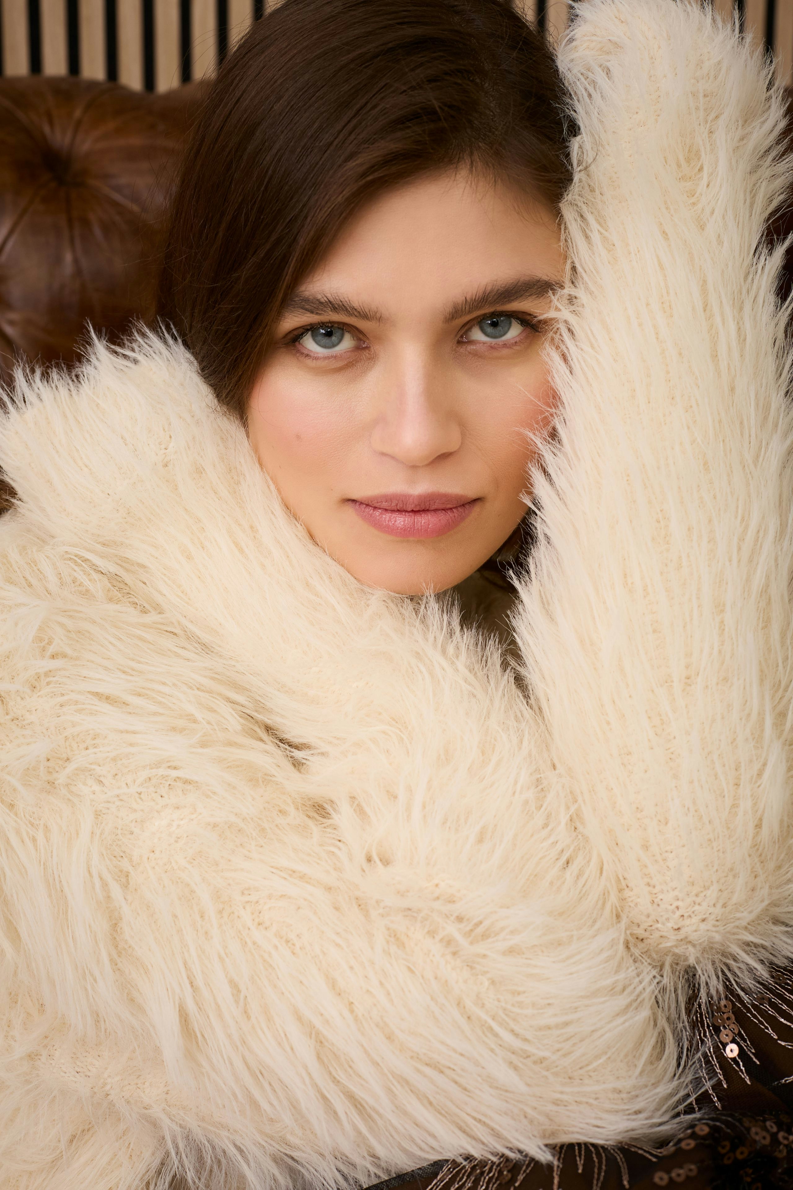 Cozy women's pullover: A woman in a fluffy cream pullover, exuding warmth and comfort.