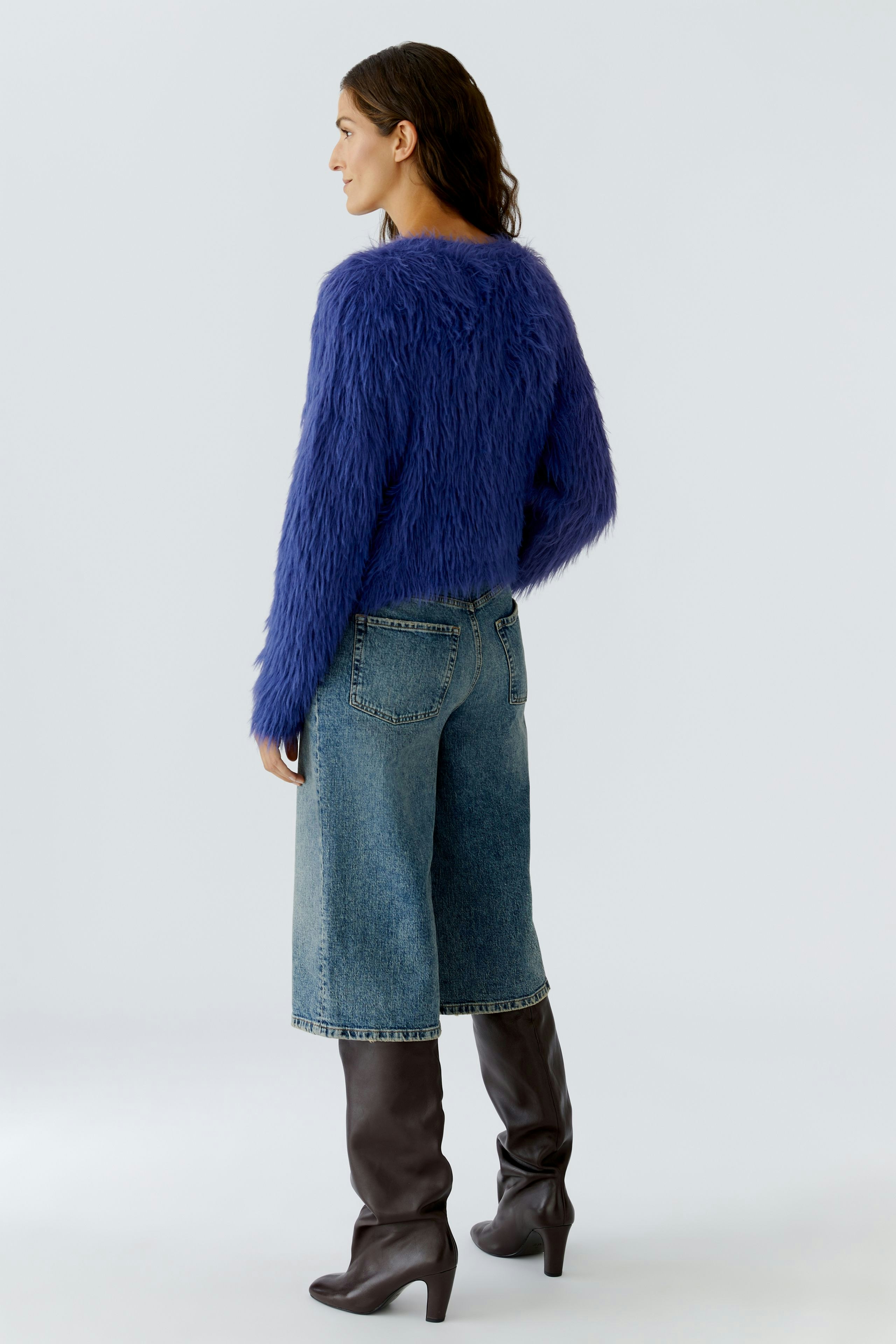 Casual women's pullover: A woman in a fluffy purple pullover and denim culottes stands confidently.