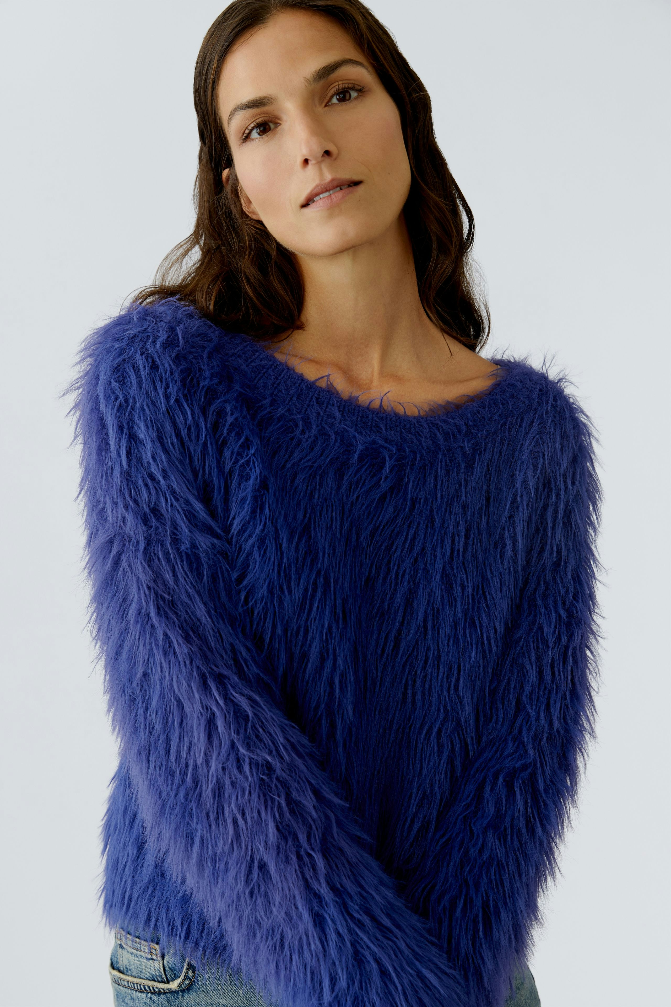 Cozy women's pullover: Woman in a fluffy blue pullover with a relaxed fit, looking confidently at the camera.