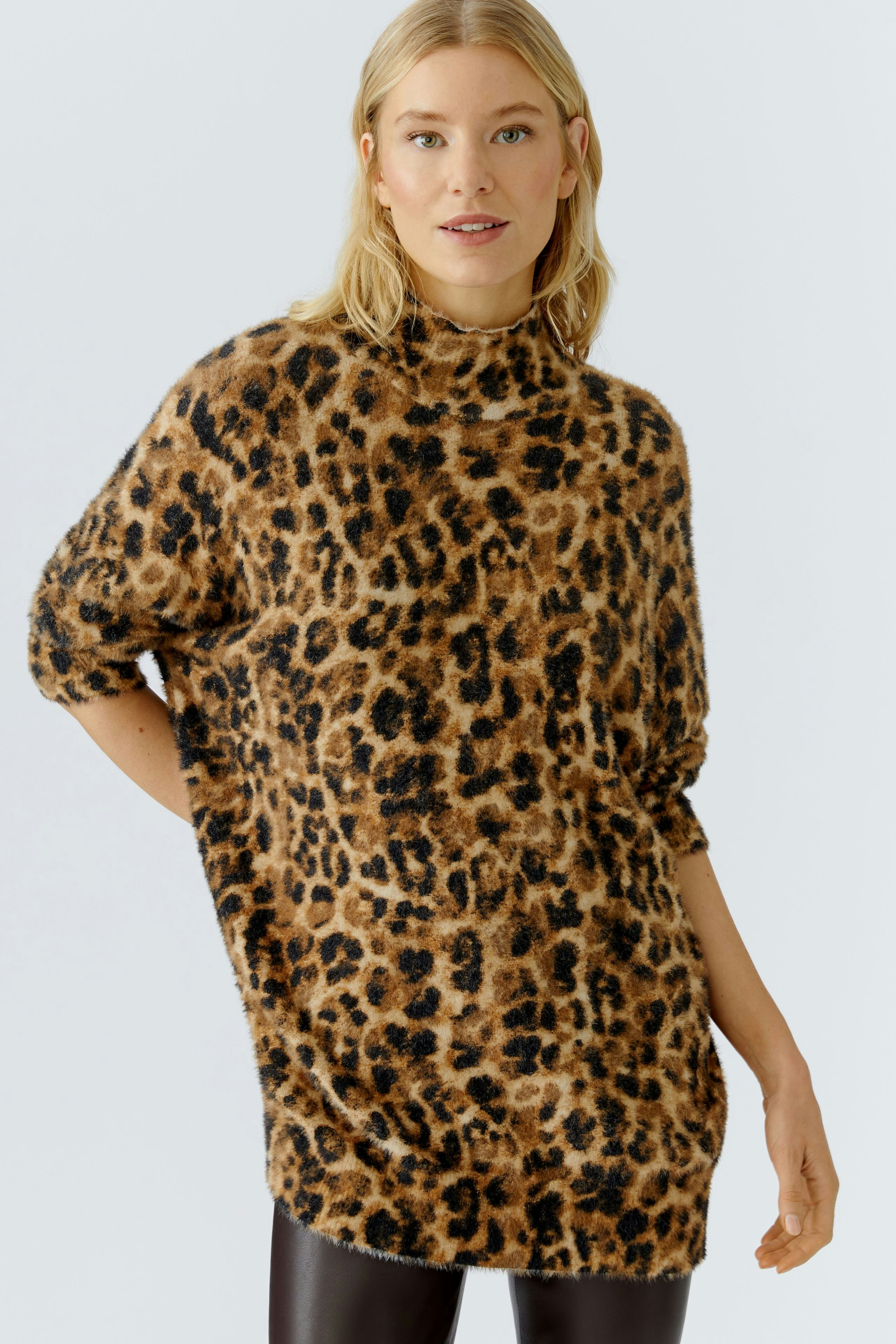 Casual women's pullover: A woman in a leopard print pullover with a relaxed fit.