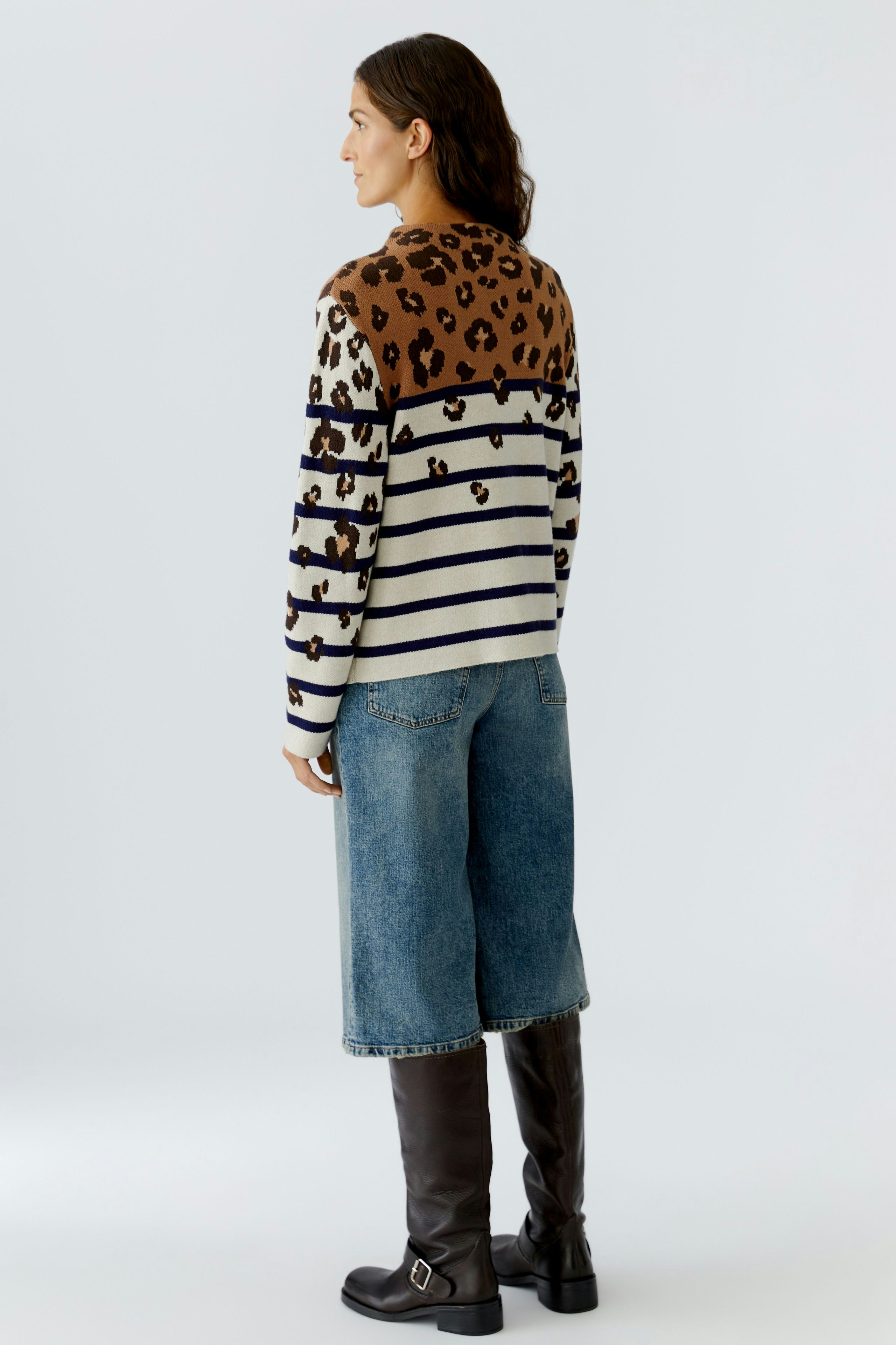 Casual women's pullover: A woman in a striped pullover with leopard print and relaxed denim pants.