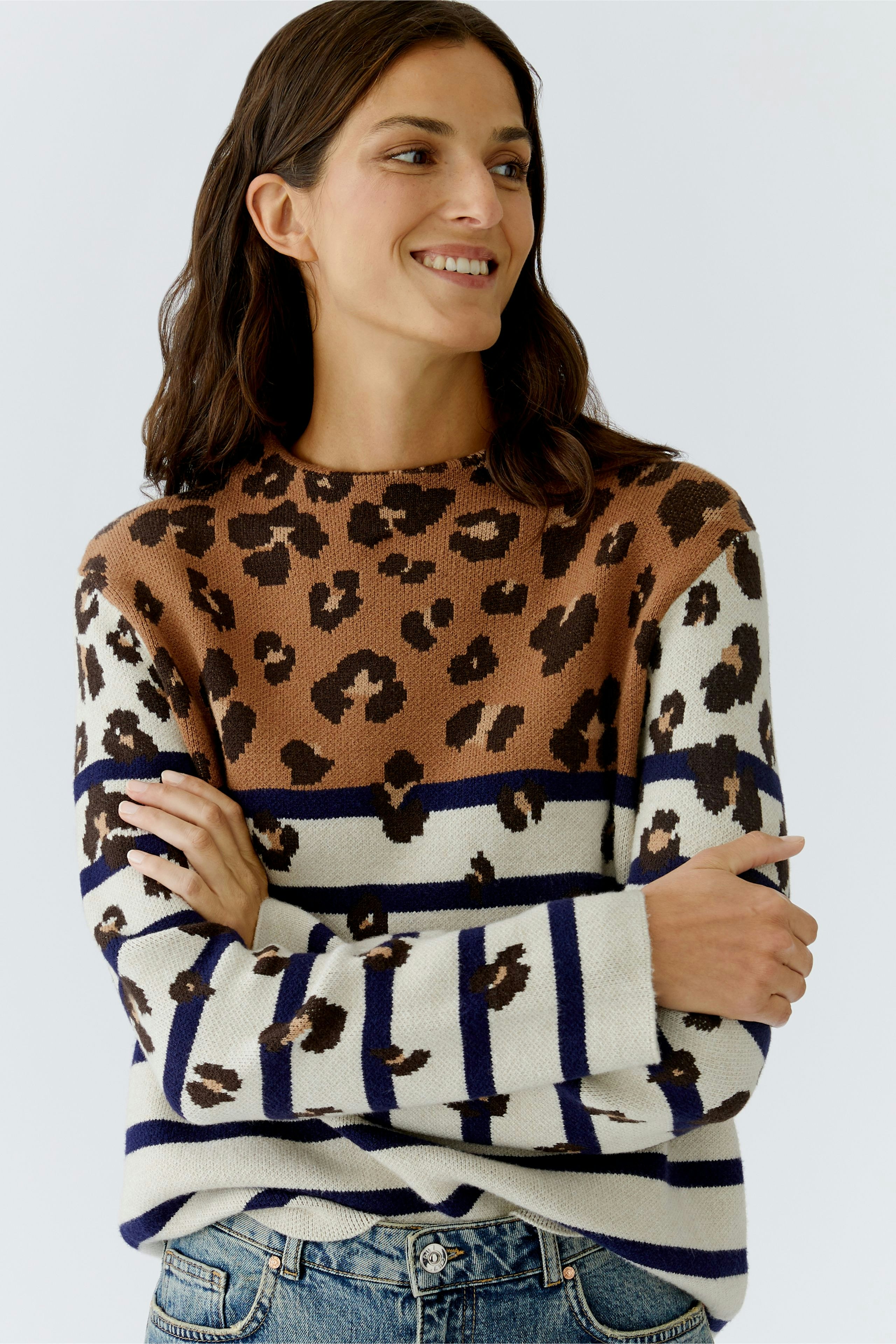 Casual women's pullover: Smiling woman in a brown and white striped pullover with leopard print.