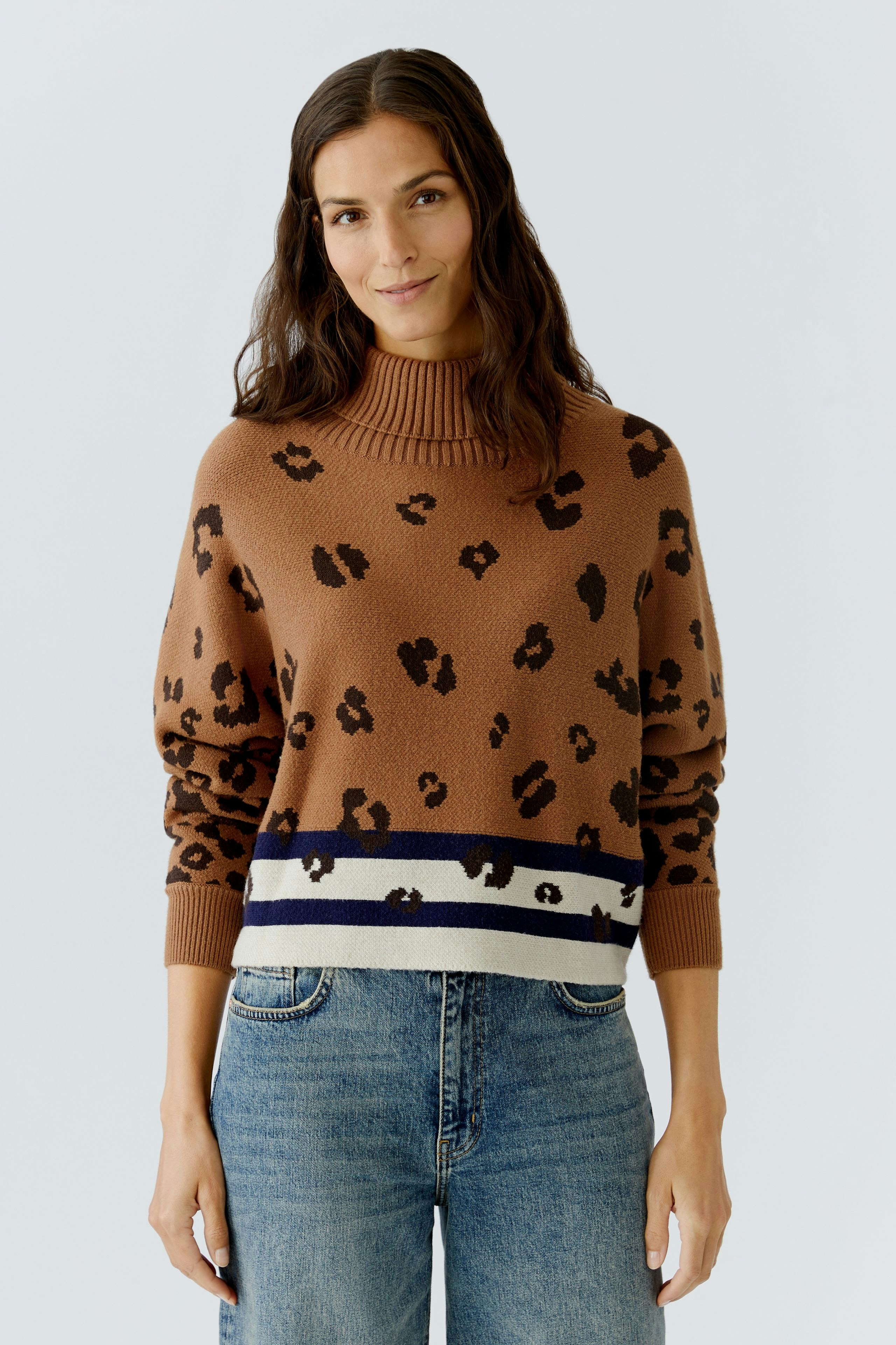 Casual women's pullover: A woman in a brown leopard print pullover with a striped hem and relaxed fit.