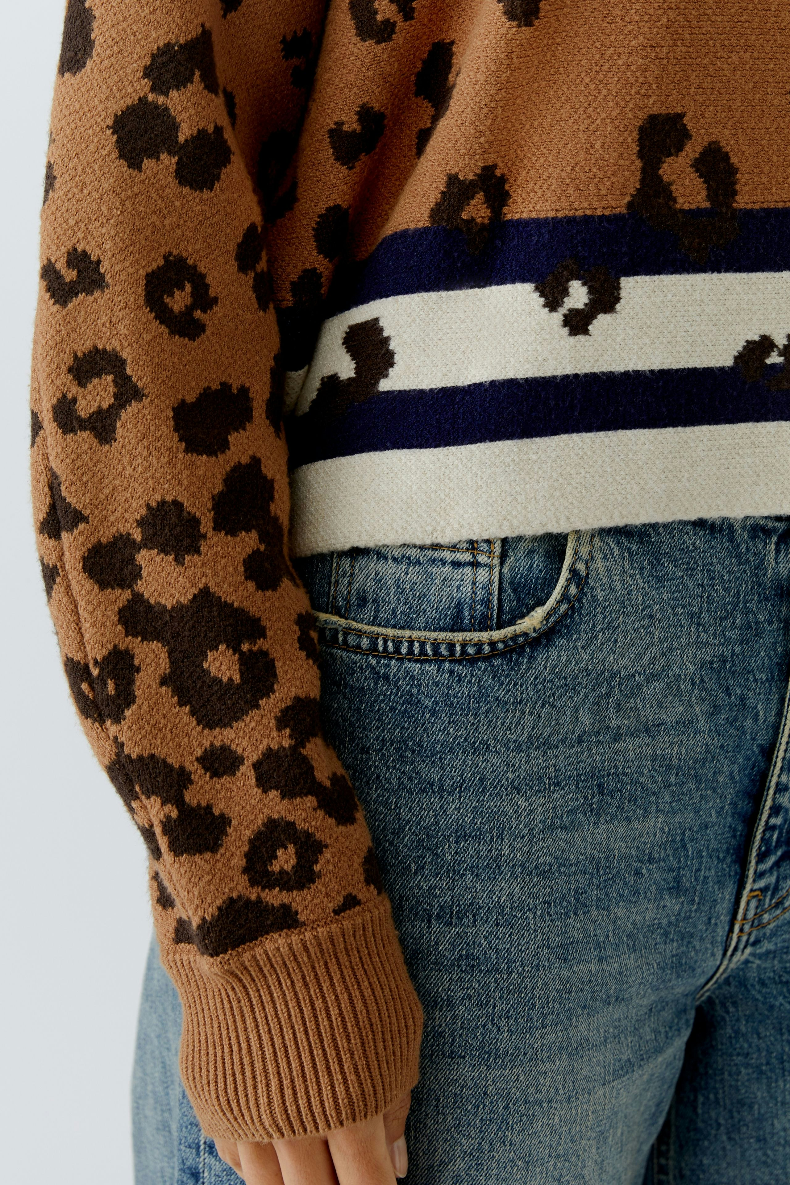 Casual women's pullover: Brown leopard print with stripes, paired with blue jeans.