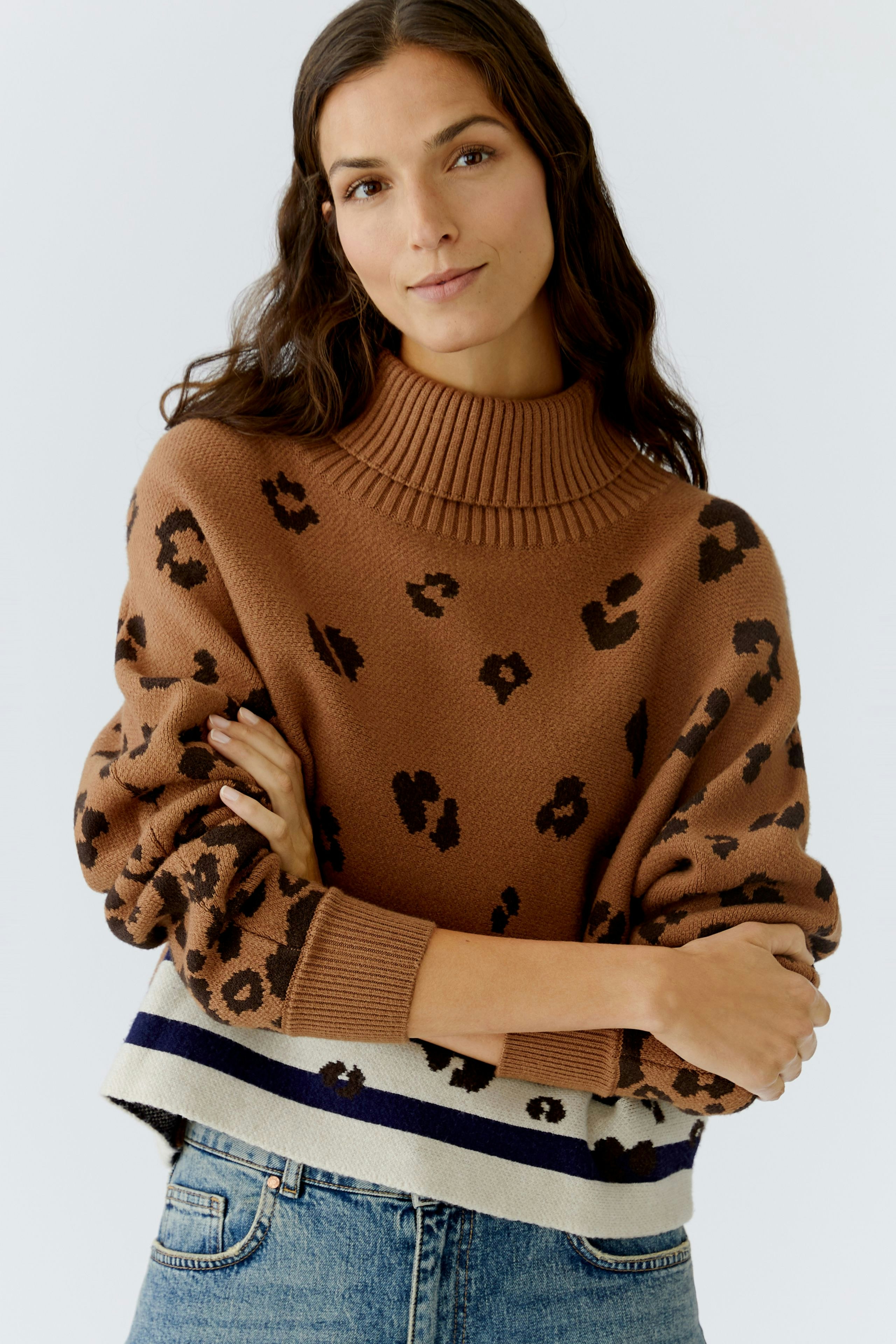 Casual women's pullover: A woman in a brown leopard print pullover with a high neck and relaxed fit.