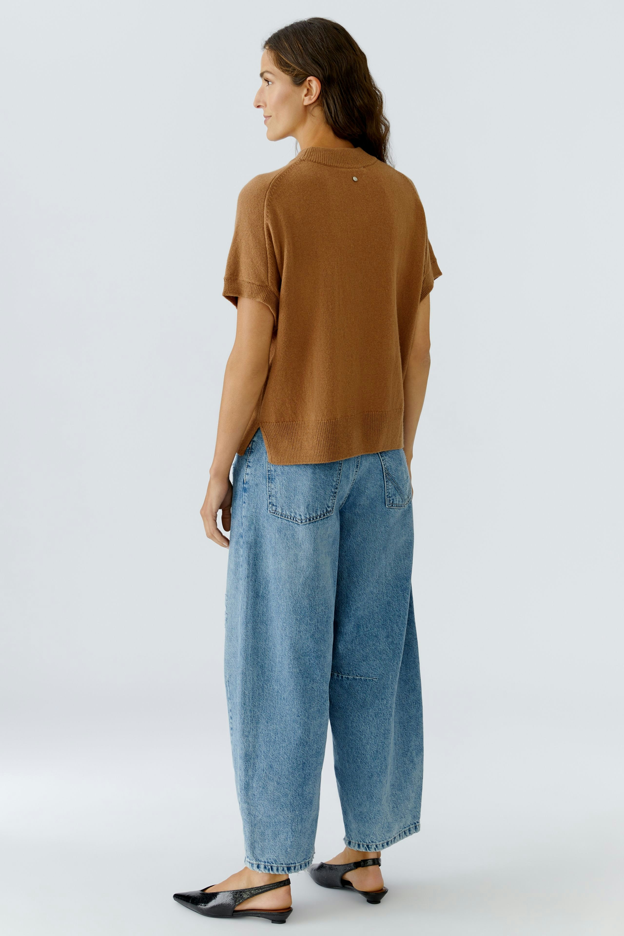 Casual women's pullover: A woman in a brown short-sleeve pullover paired with loose jeans.