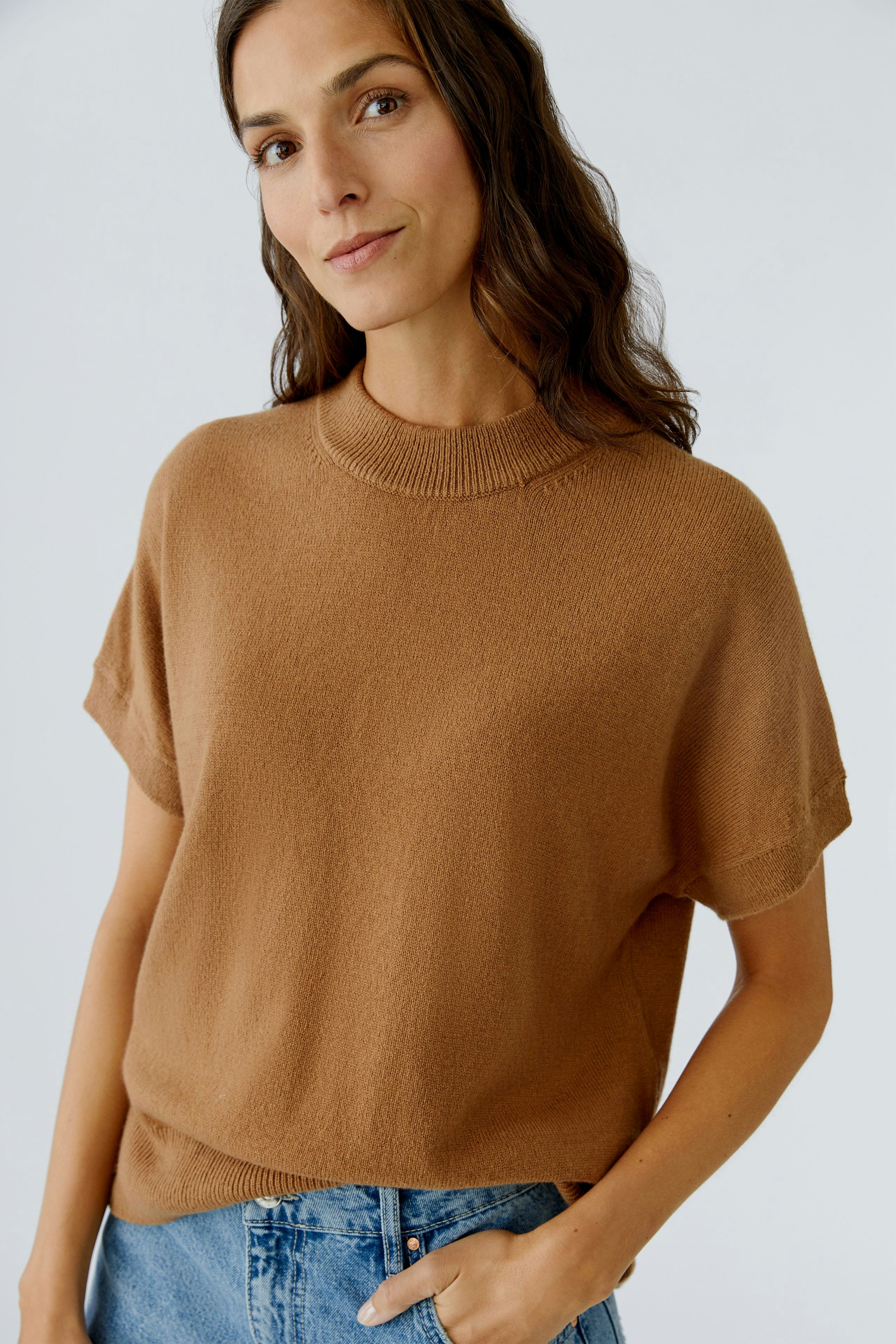Casual women's pullover: A woman in a brown short-sleeve pullover paired with denim shorts.