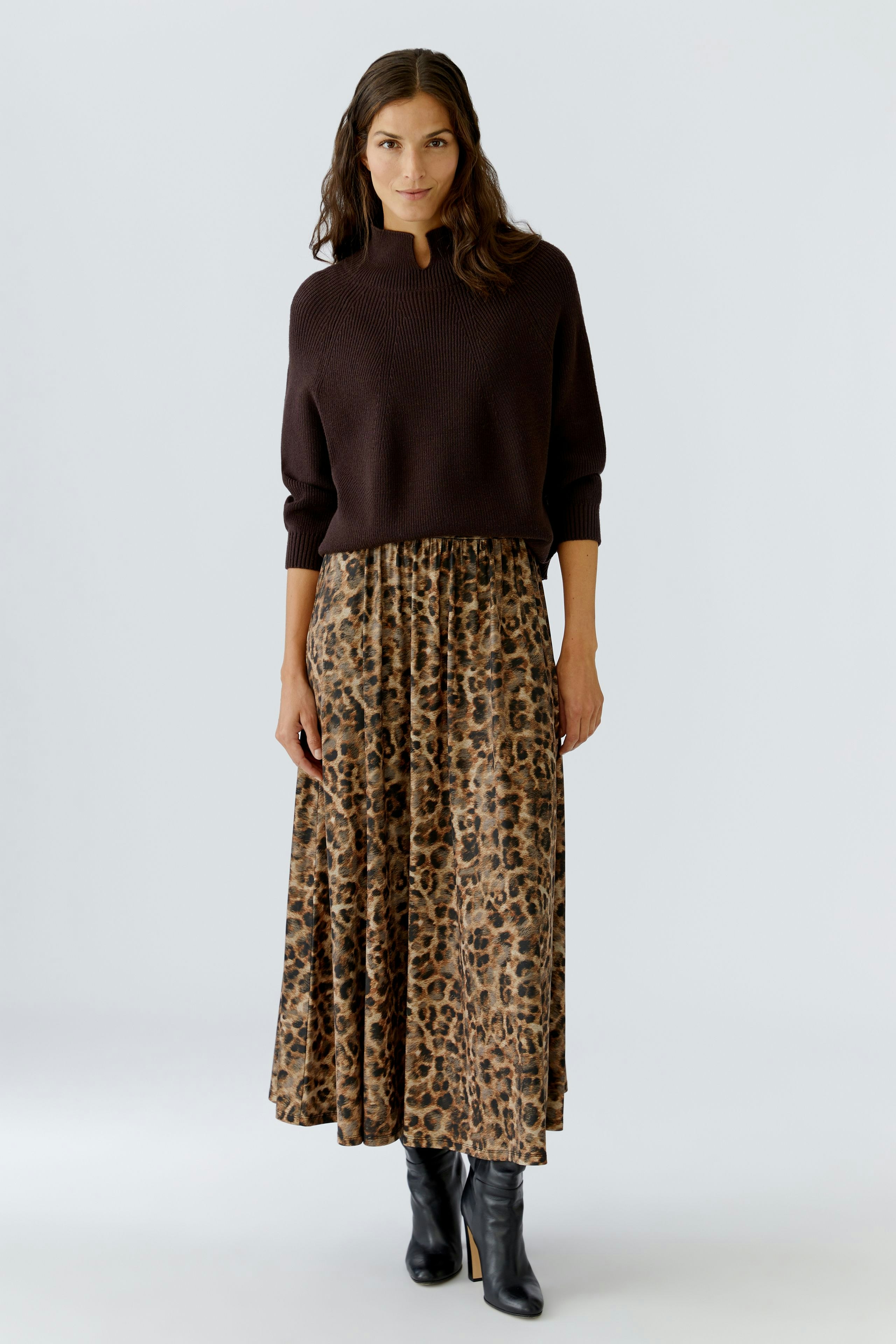 Casual women's pullover: A woman in a dark brown pullover paired with a leopard print skirt.
