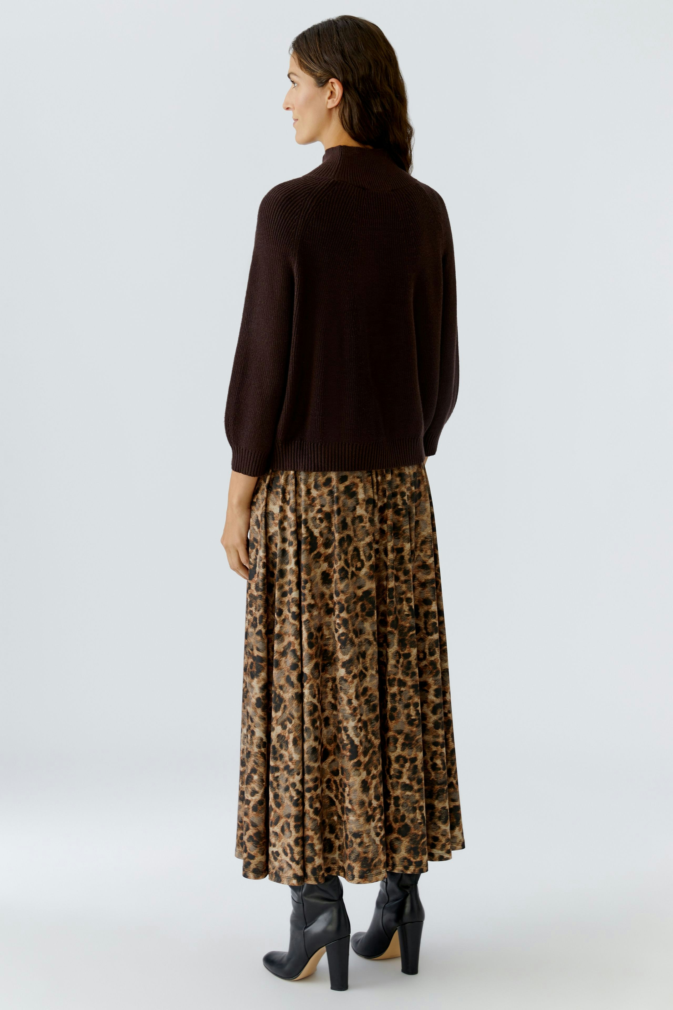 Casual women's pullover: A woman in a brown pullover paired with a leopard print skirt.