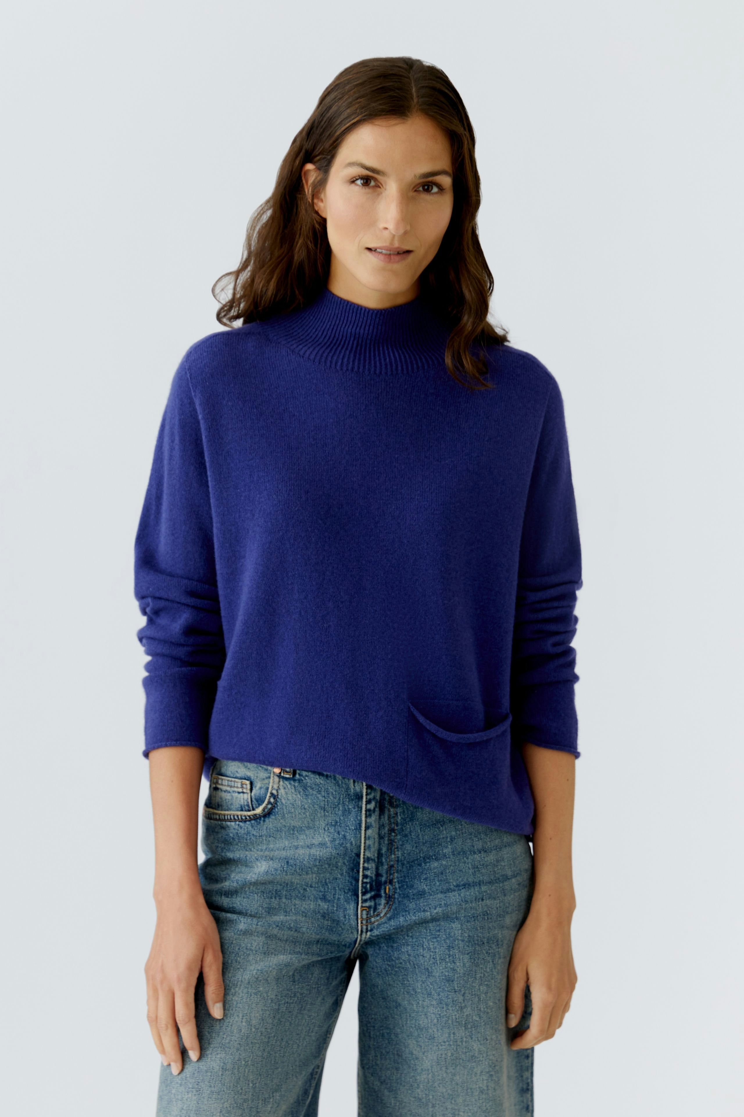 Casual women's pullover: A woman in a purple pullover with a relaxed fit and a front pocket.