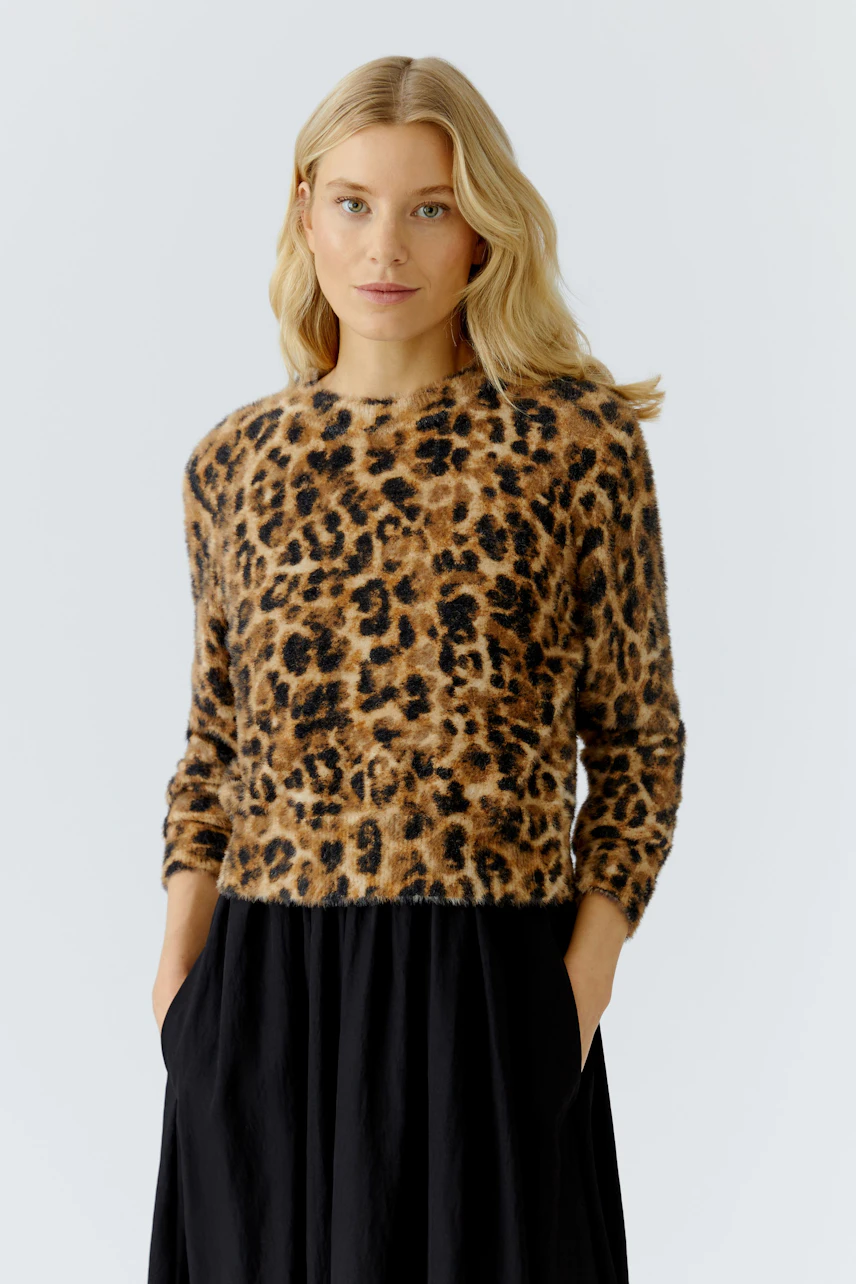 Damen-Pullover: Frau im braunen Pullover mit Leopardenmuster und lässiger Rock-Optik.