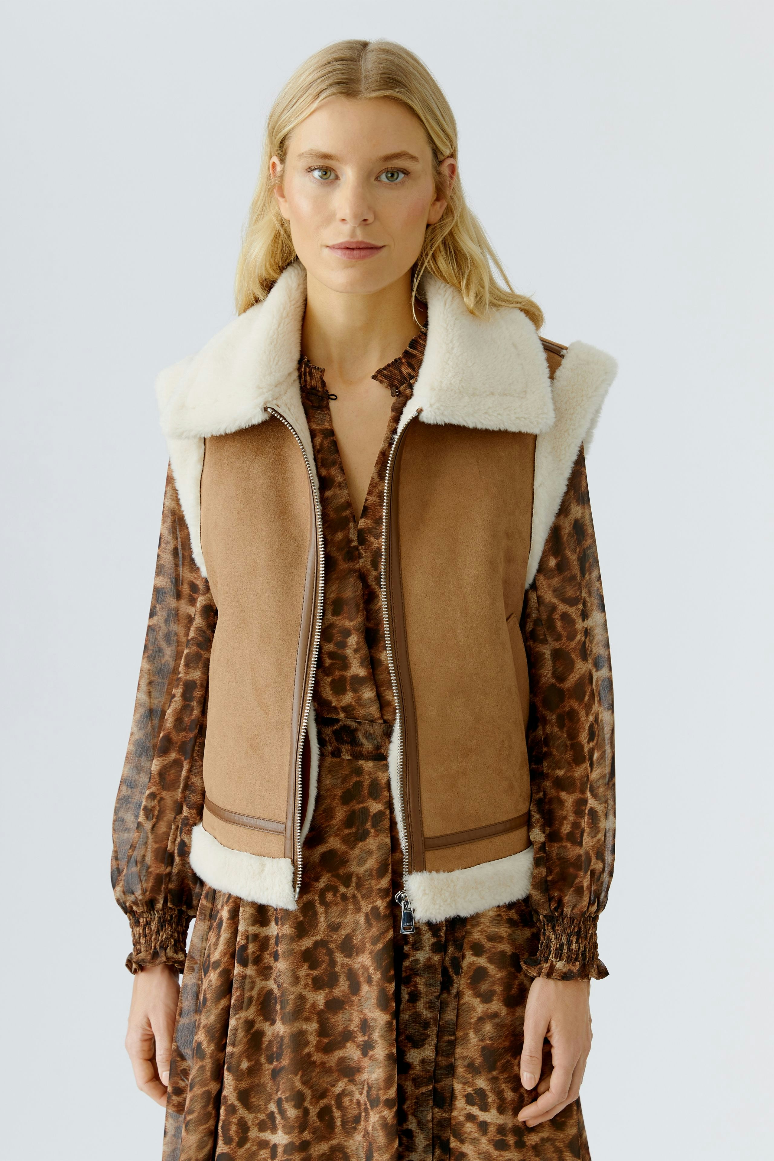 Stylish women's vest: A woman in a brown vest with a soft collar, paired with a patterned dress.