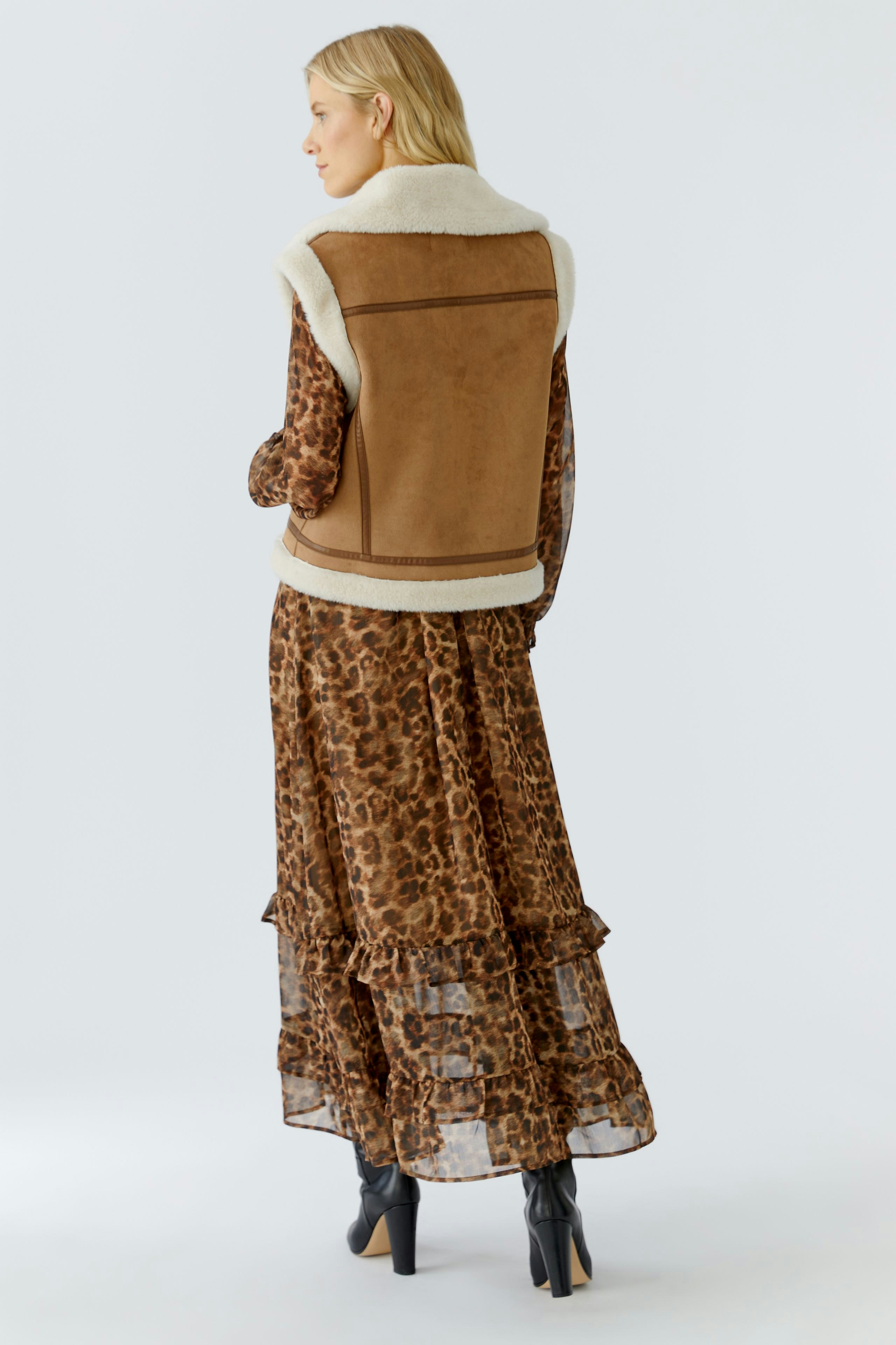 Casual women's vest: A woman in a brown vest with a soft collar over a patterned dress.