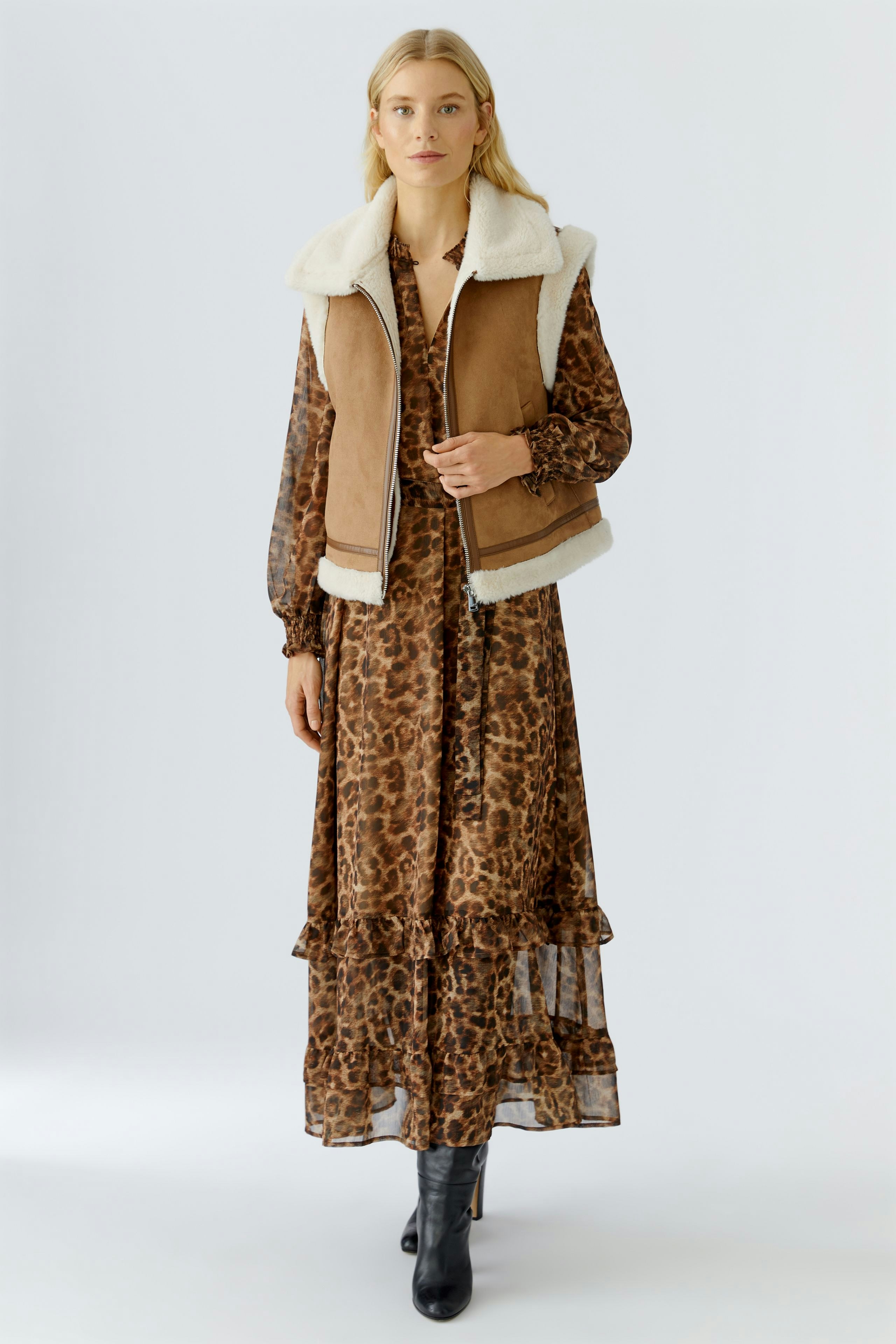 Casual women's vest: A woman in a brown vest with a soft collar over a leopard print dress.