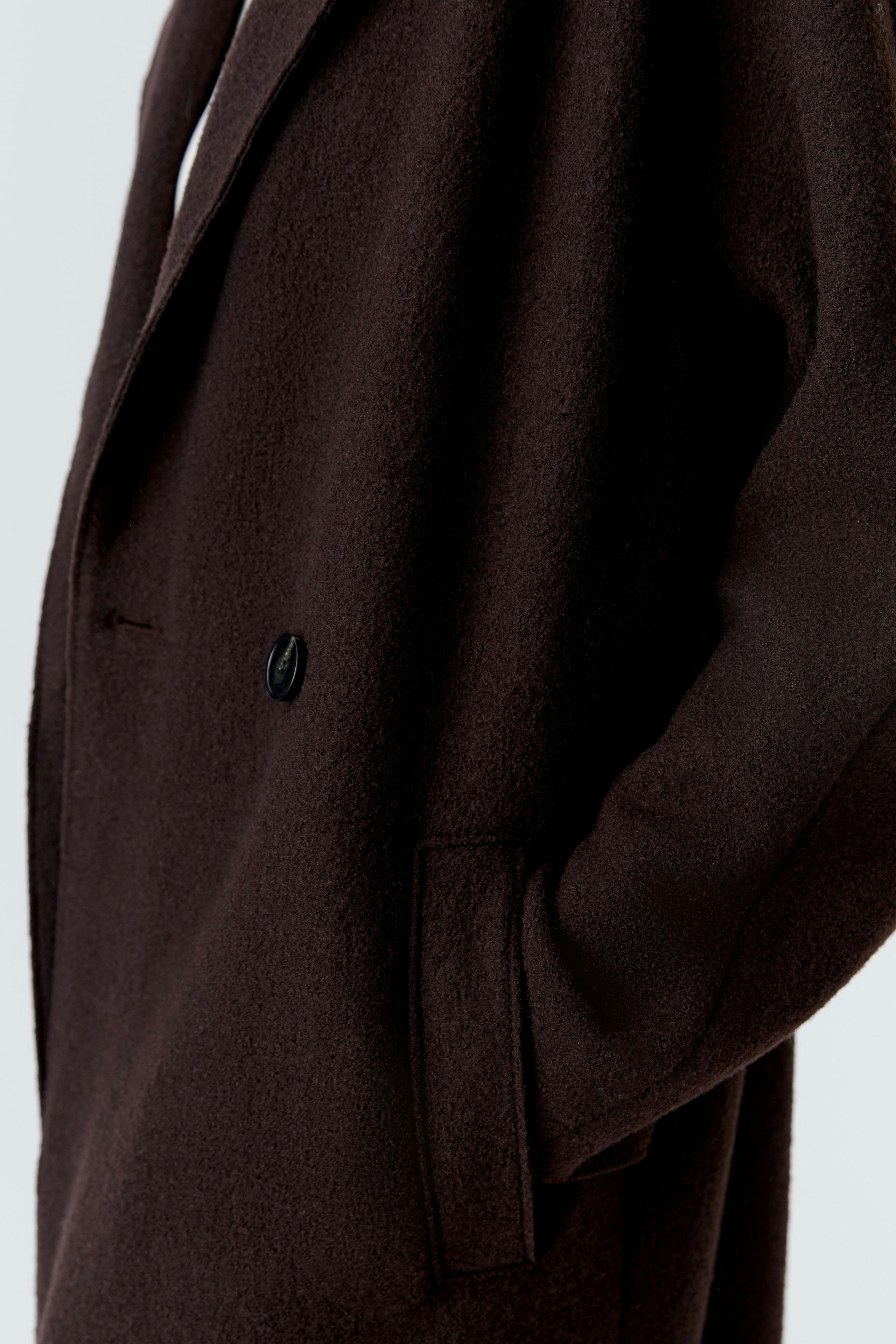 Stylish women's winter coat in dark brown with a relaxed fit and side pockets.