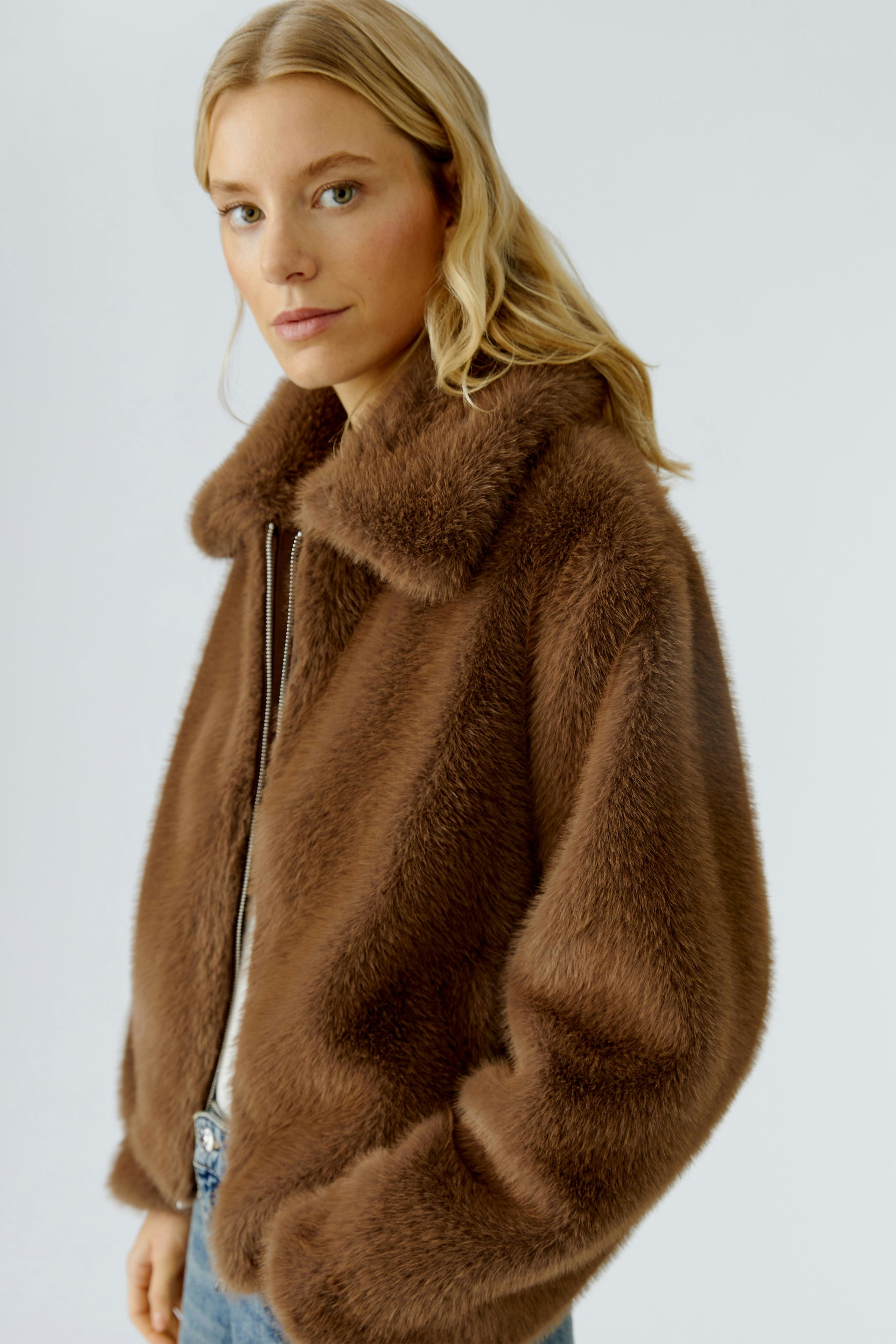 Cozy women's jacket: A woman in a soft brown jacket with a collar, exuding casual comfort.