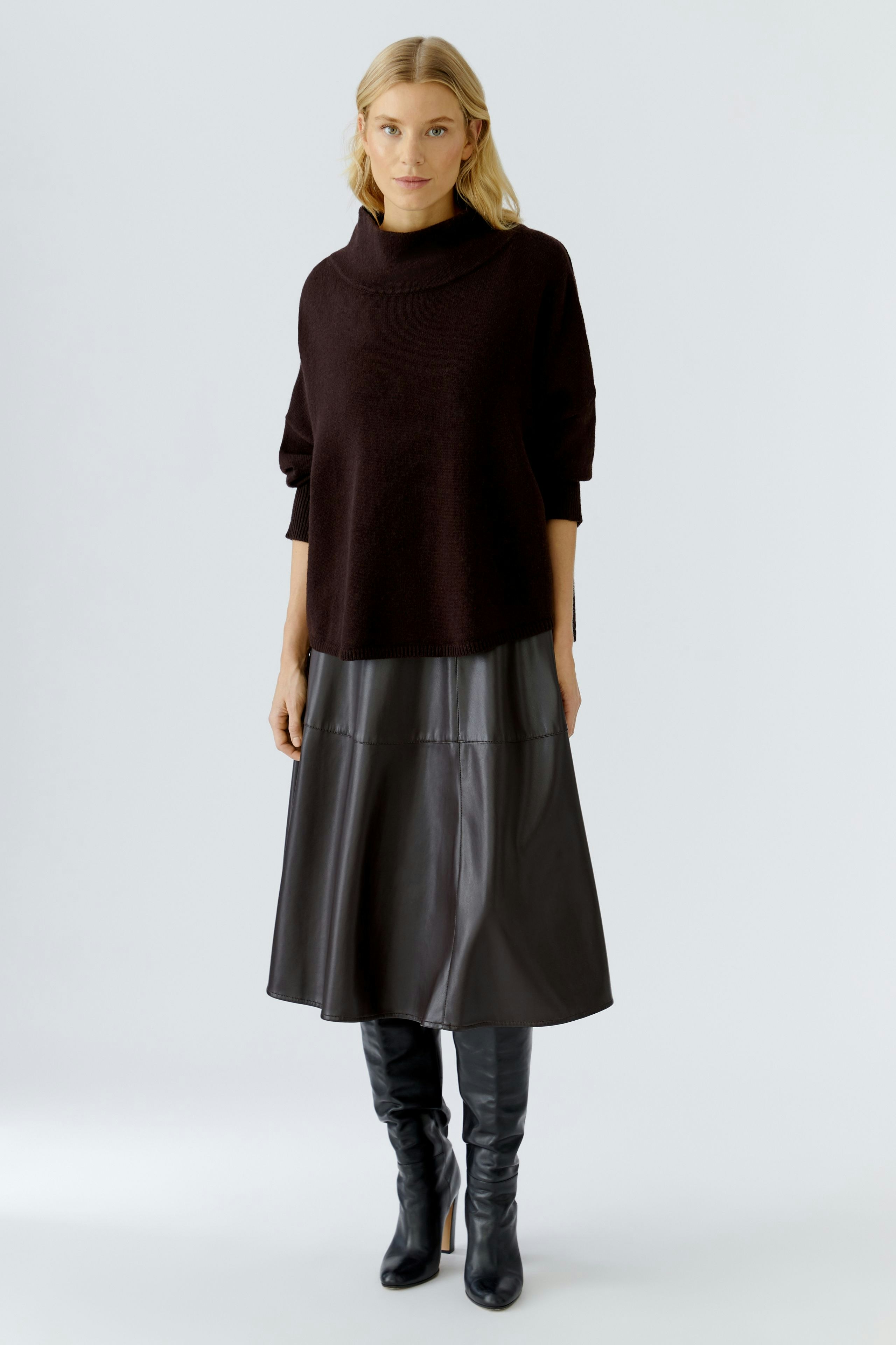 A-line skirt: Woman in a relaxed fit, black A-line skirt paired with a cozy pullover.