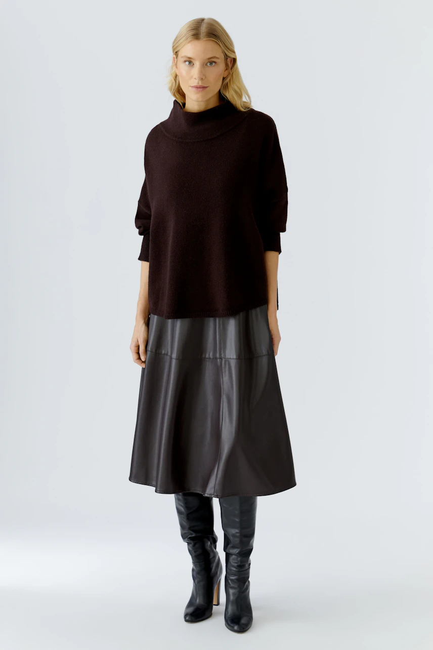 A-line skirt: Woman in a relaxed fit, black A-line skirt paired with a cozy pullover.