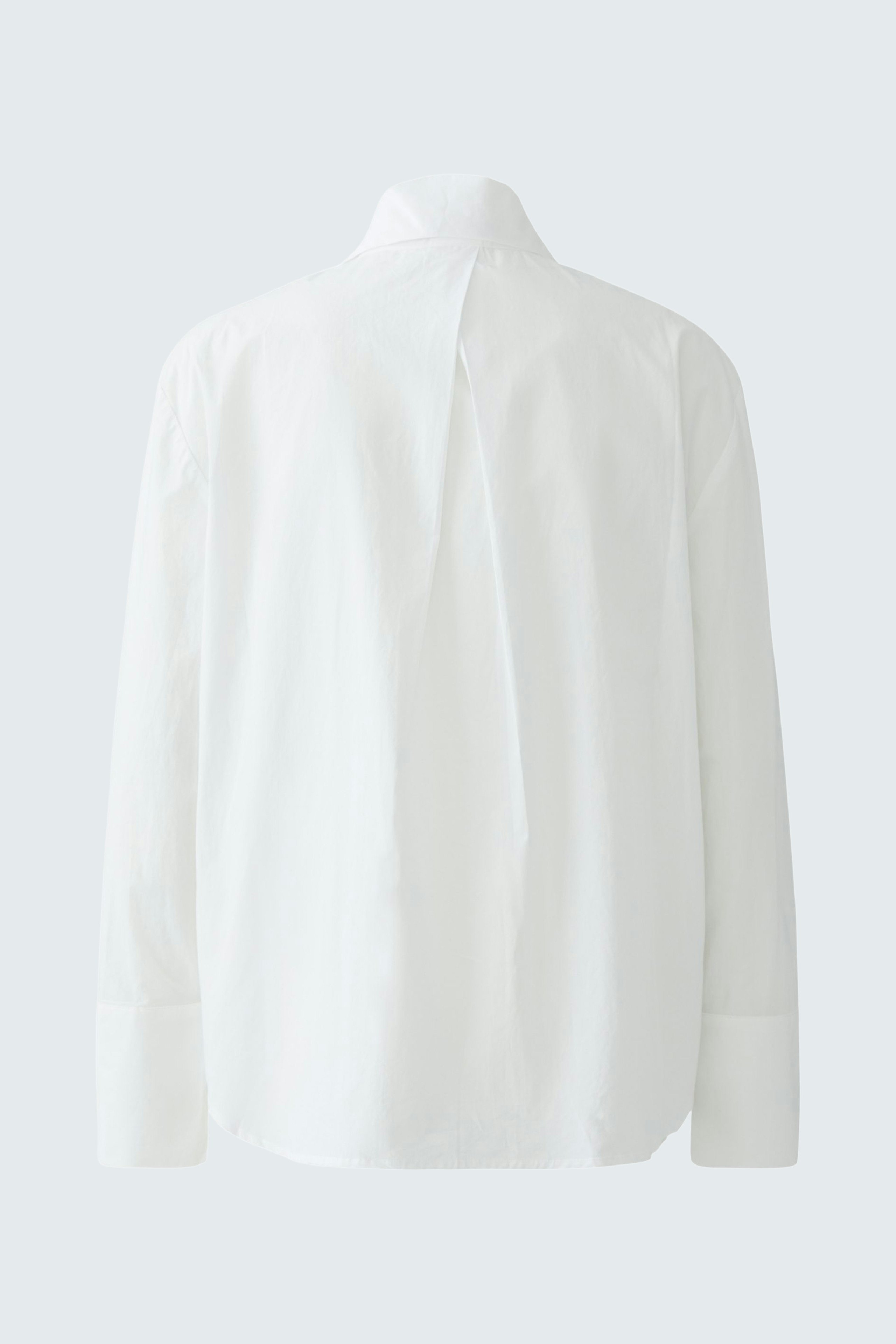 Casual women's blouse: A woman in a white blouse with a simple design, showcasing a relaxed style.