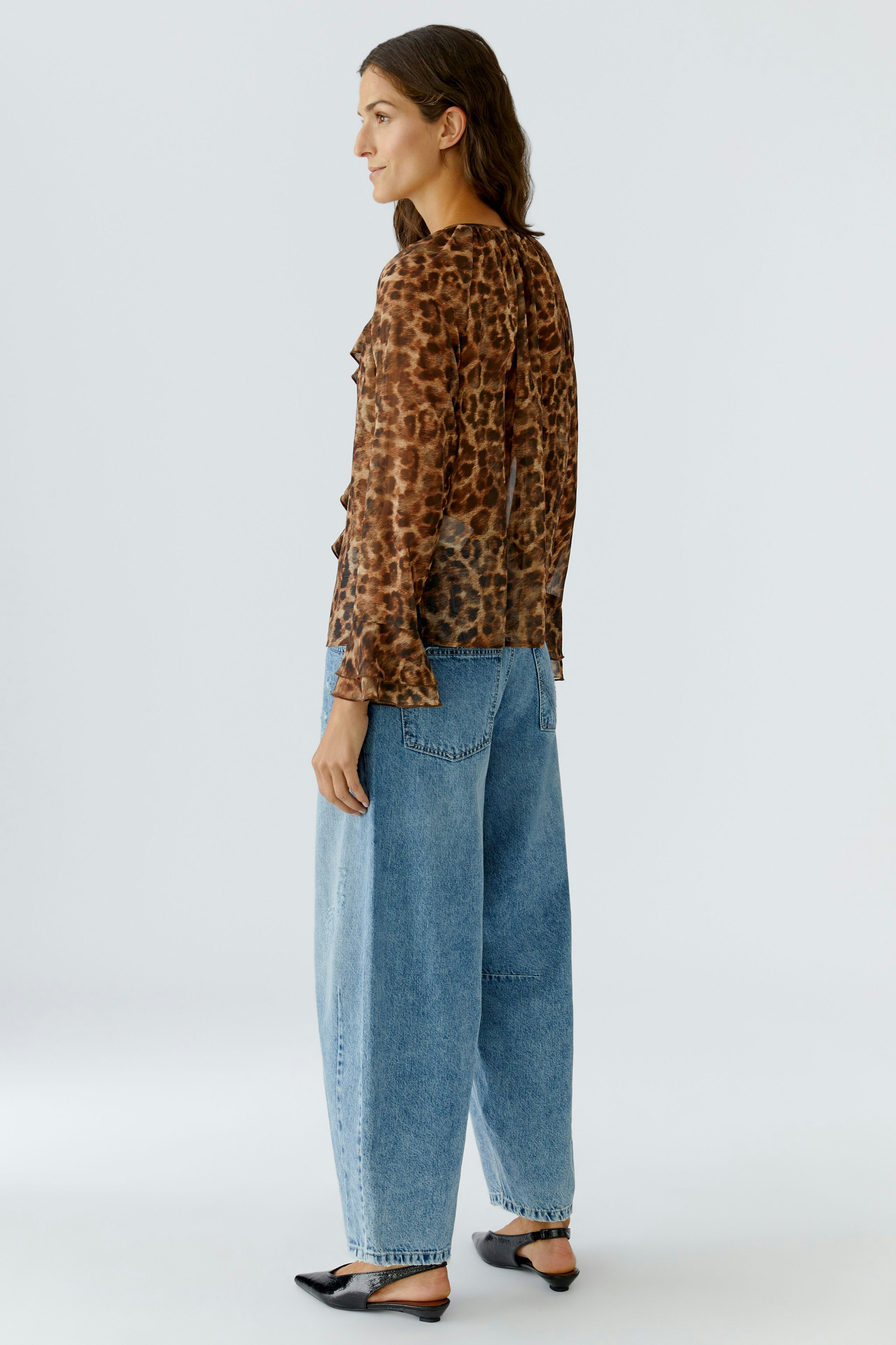 Casual women's blouse: A woman in a leopard print blouse paired with relaxed-fit jeans.