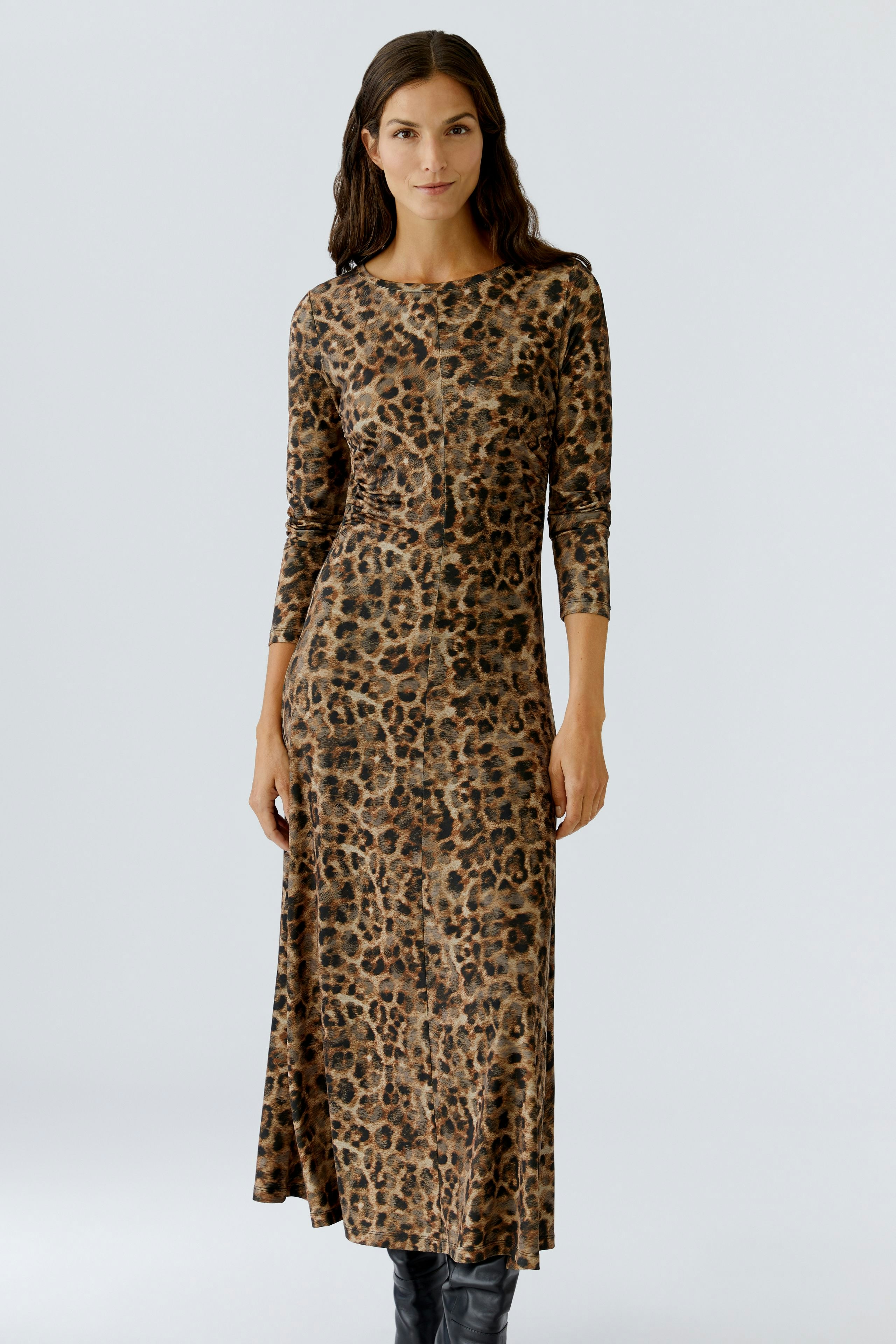 Leopard print dress: Woman in a long-sleeve, fitted dress with a stylish animal pattern.