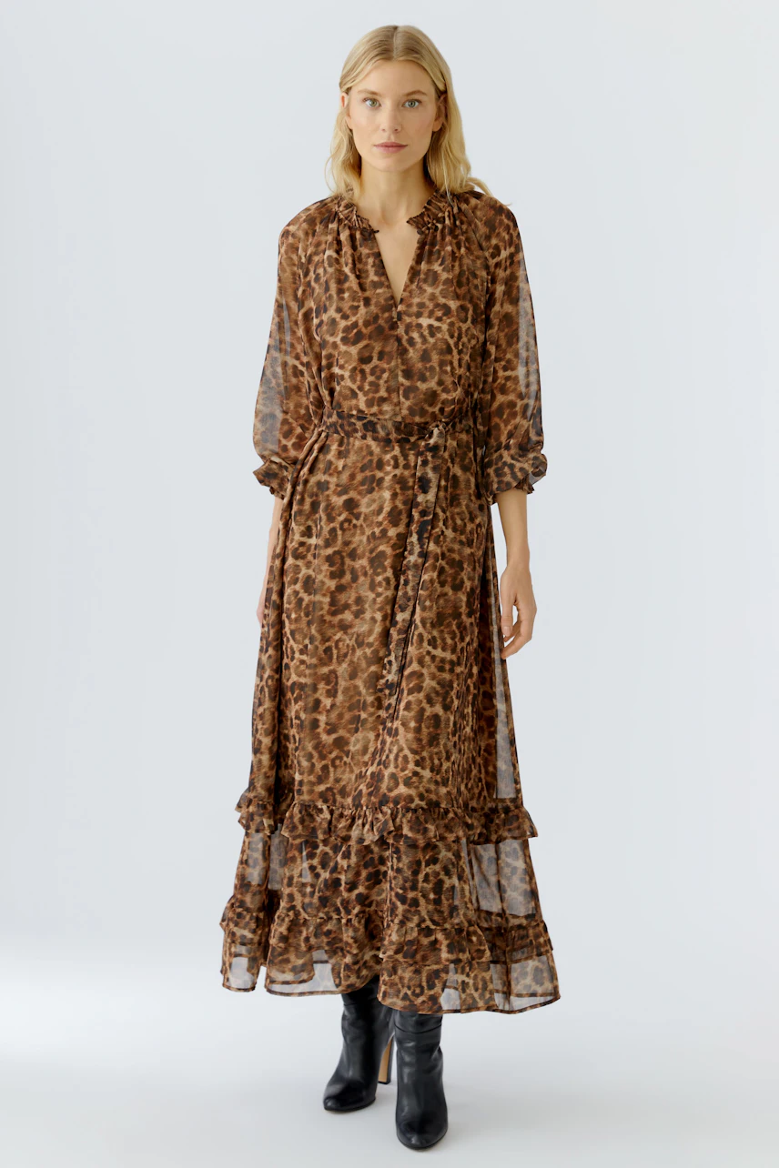 Maxikleid in Leo-Print: Frau trägt ein leichtes, fließendes Kleid mit Rüschendetails und Bindegürtel.