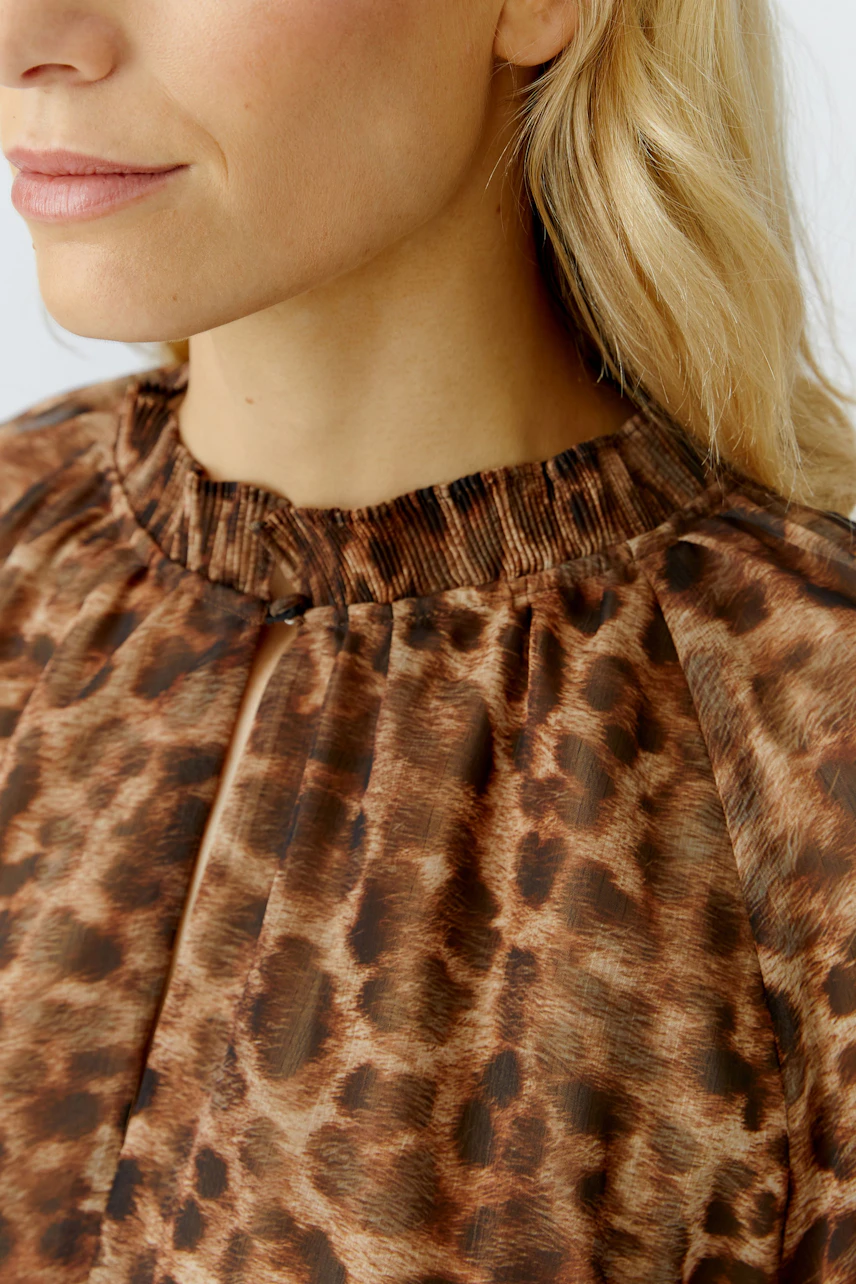 Maxikleid: Frau mit tierischem Muster, Stehkragen und lockerer Passform.
