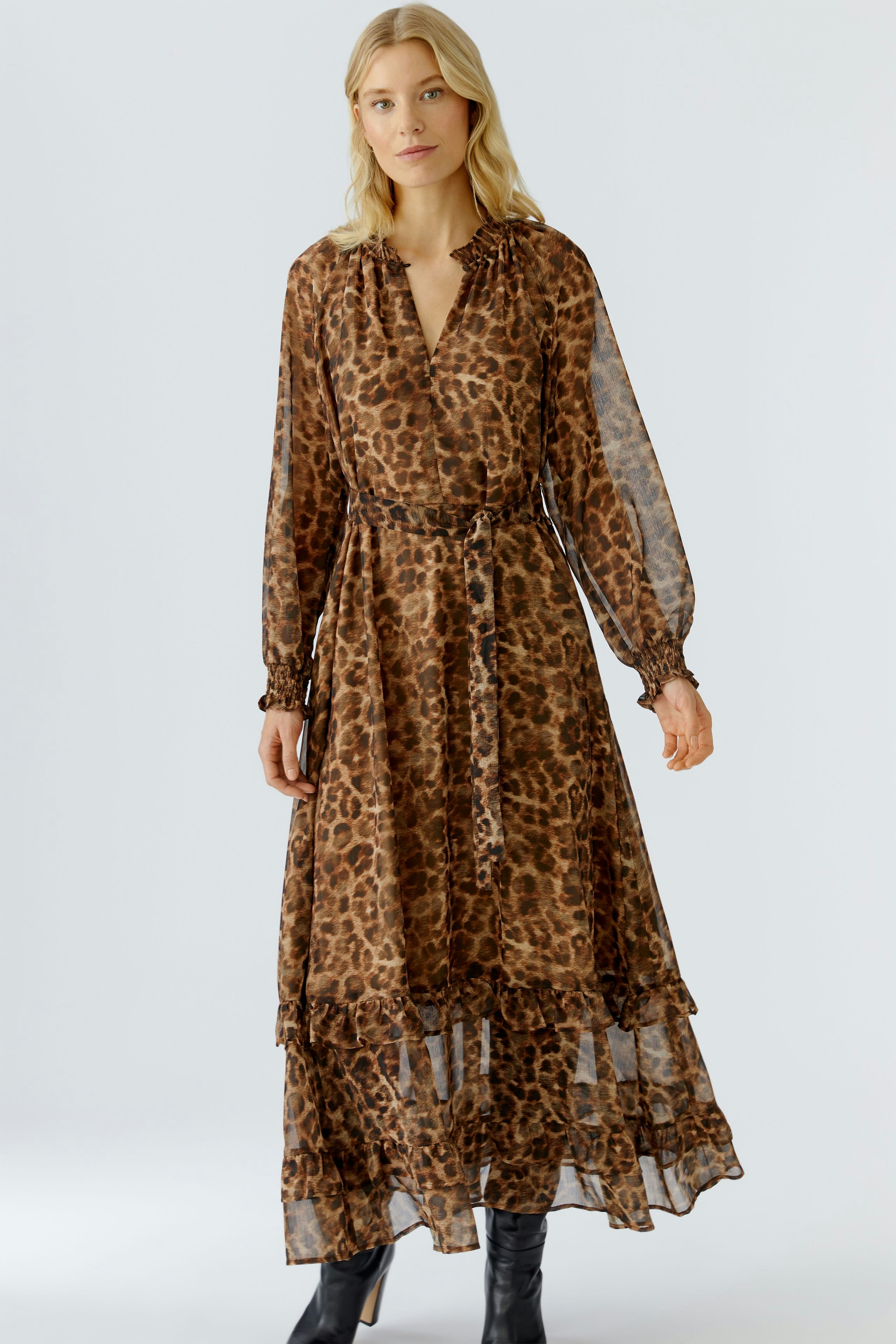 Maxi dress: Woman in a brown leopard print dress with long sleeves and a tiered skirt.