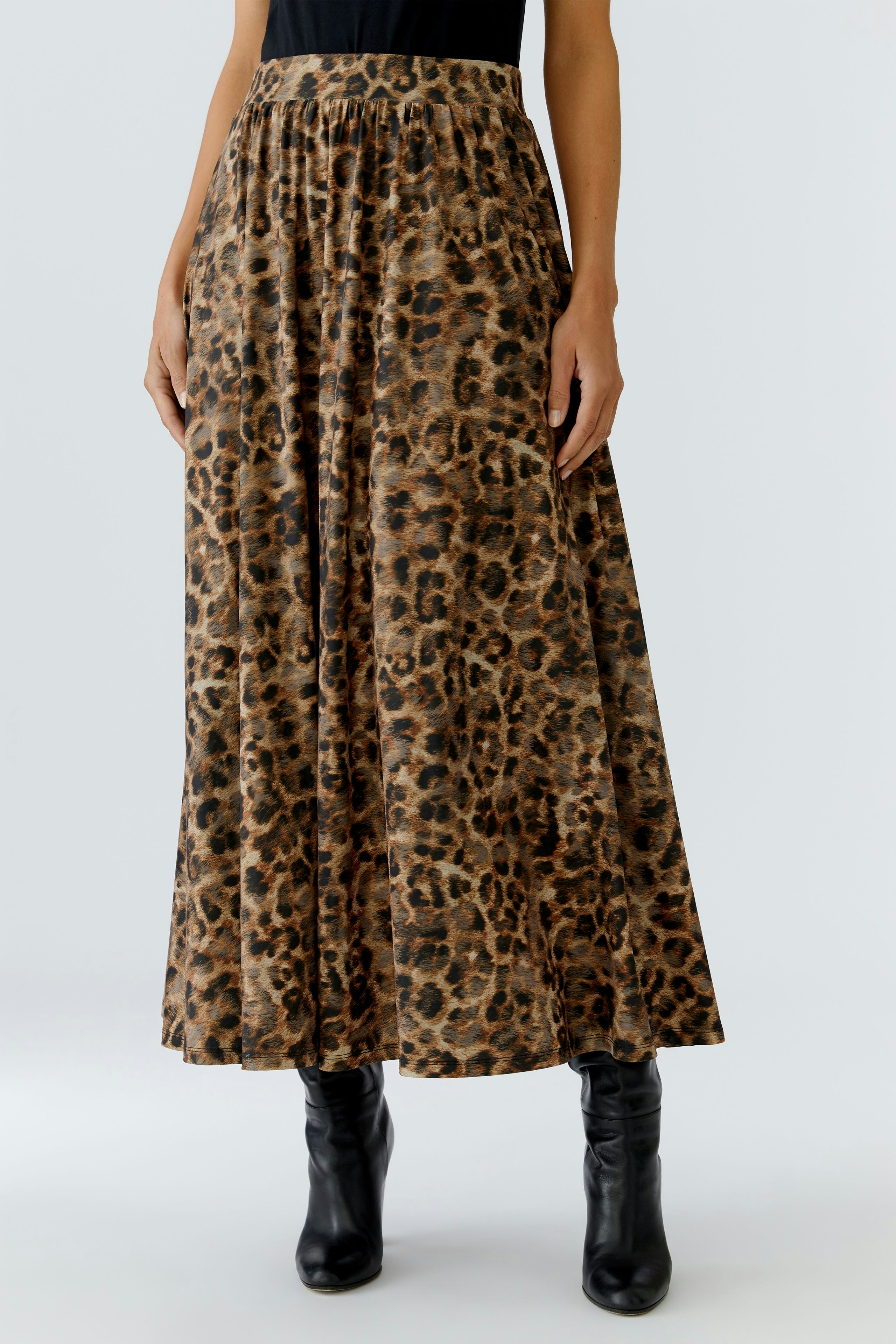 A-line skirt: Woman in a long, leopard print skirt paired with black boots.
