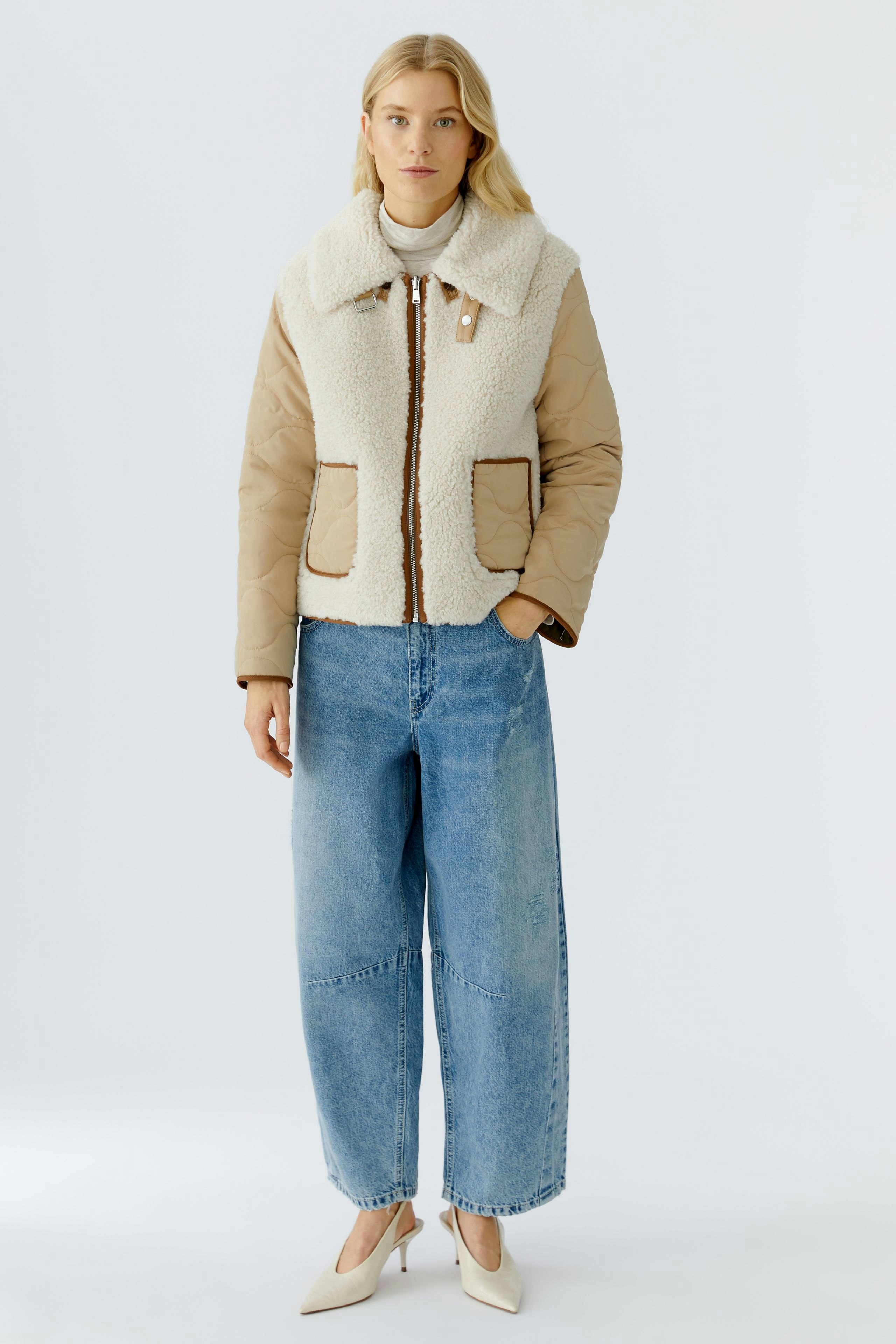 Casual women's outdoor jacket: A woman in a beige and cream jacket with pockets and a cozy collar.