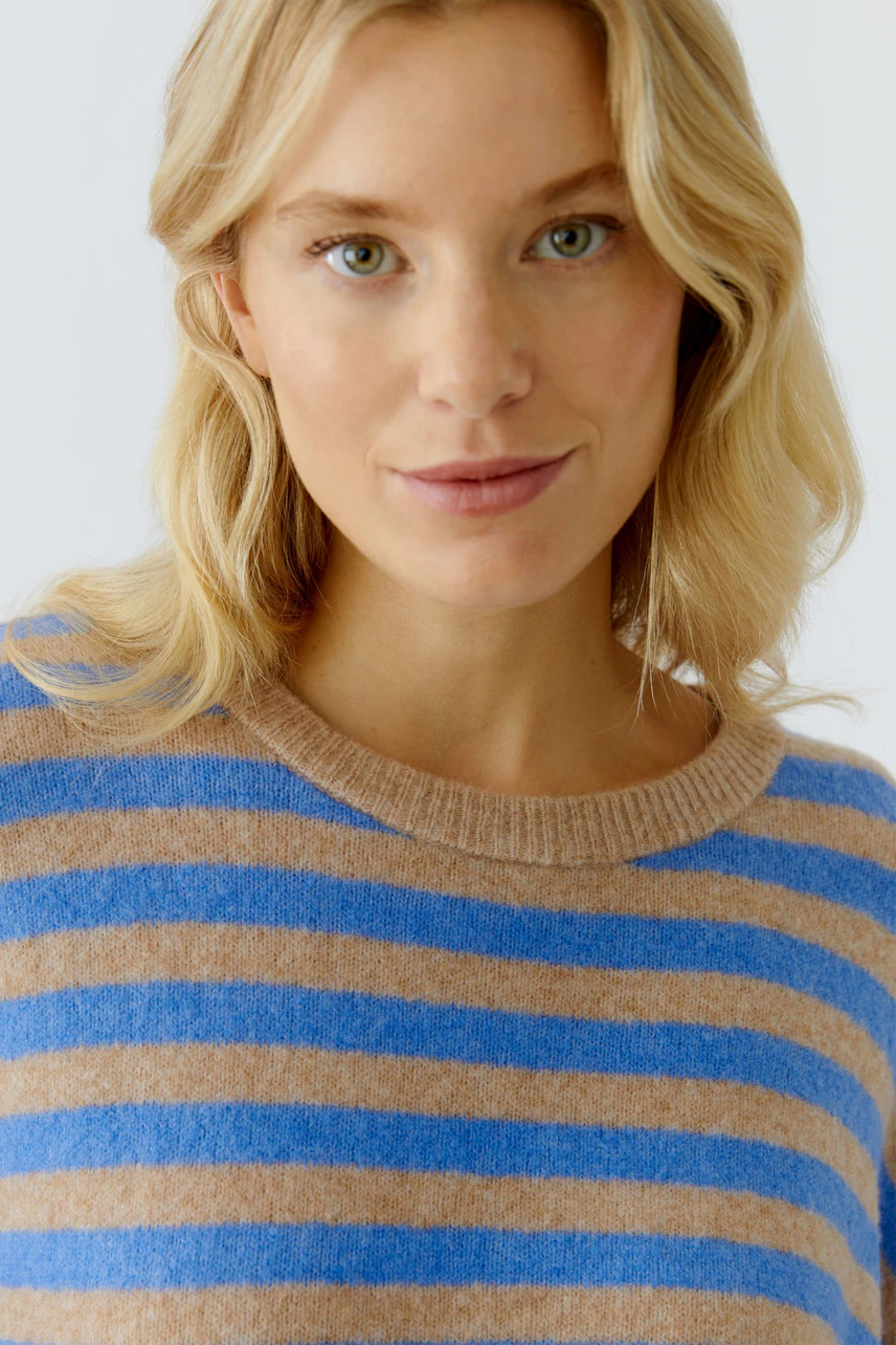 Damen-Pullover: Frau mit blauen und braunen Streifen im lässigen Strickpullover lächelt.