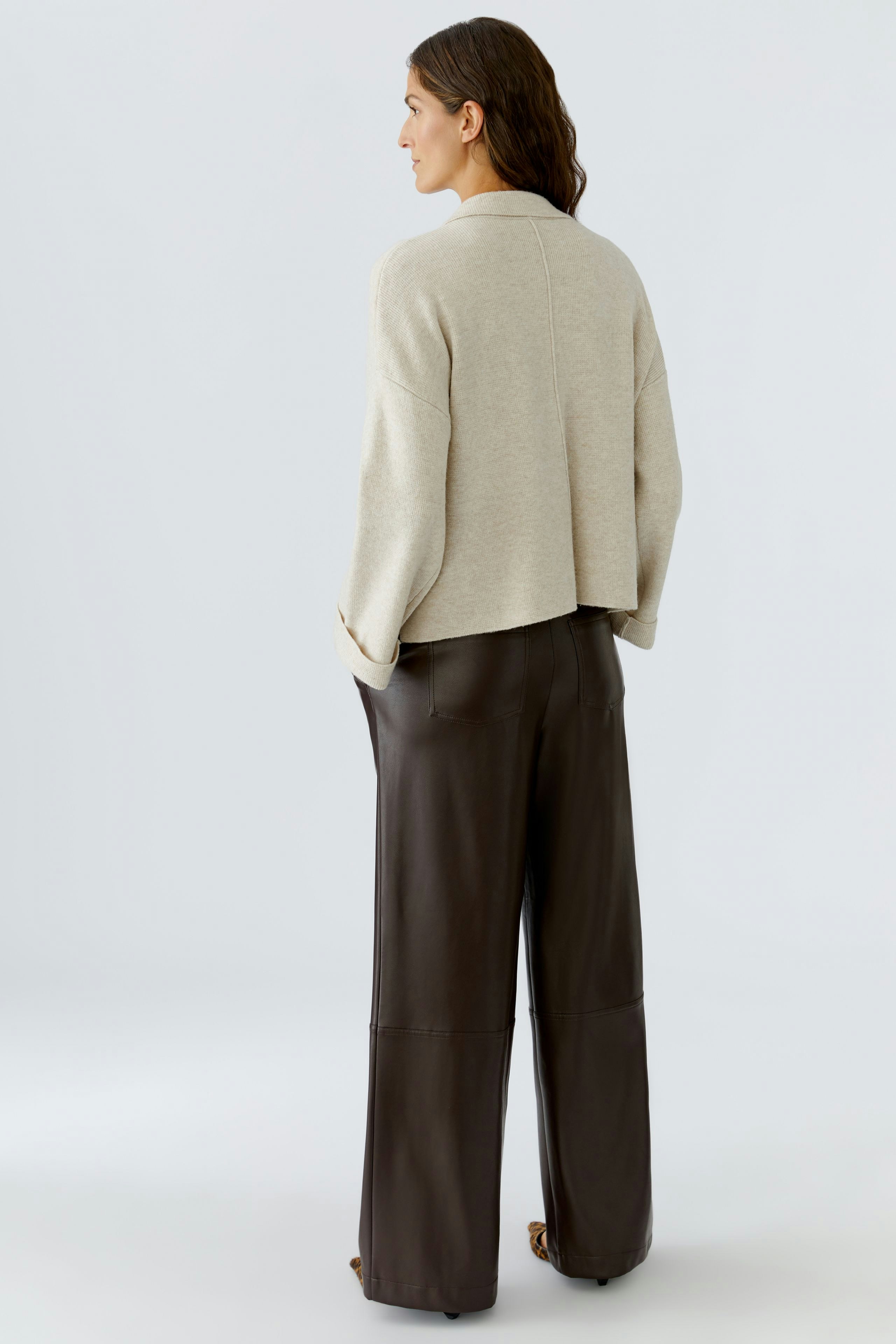 Casual women's cardigan: A woman in a light beige cardigan with a relaxed fit, paired with wide-leg pants.