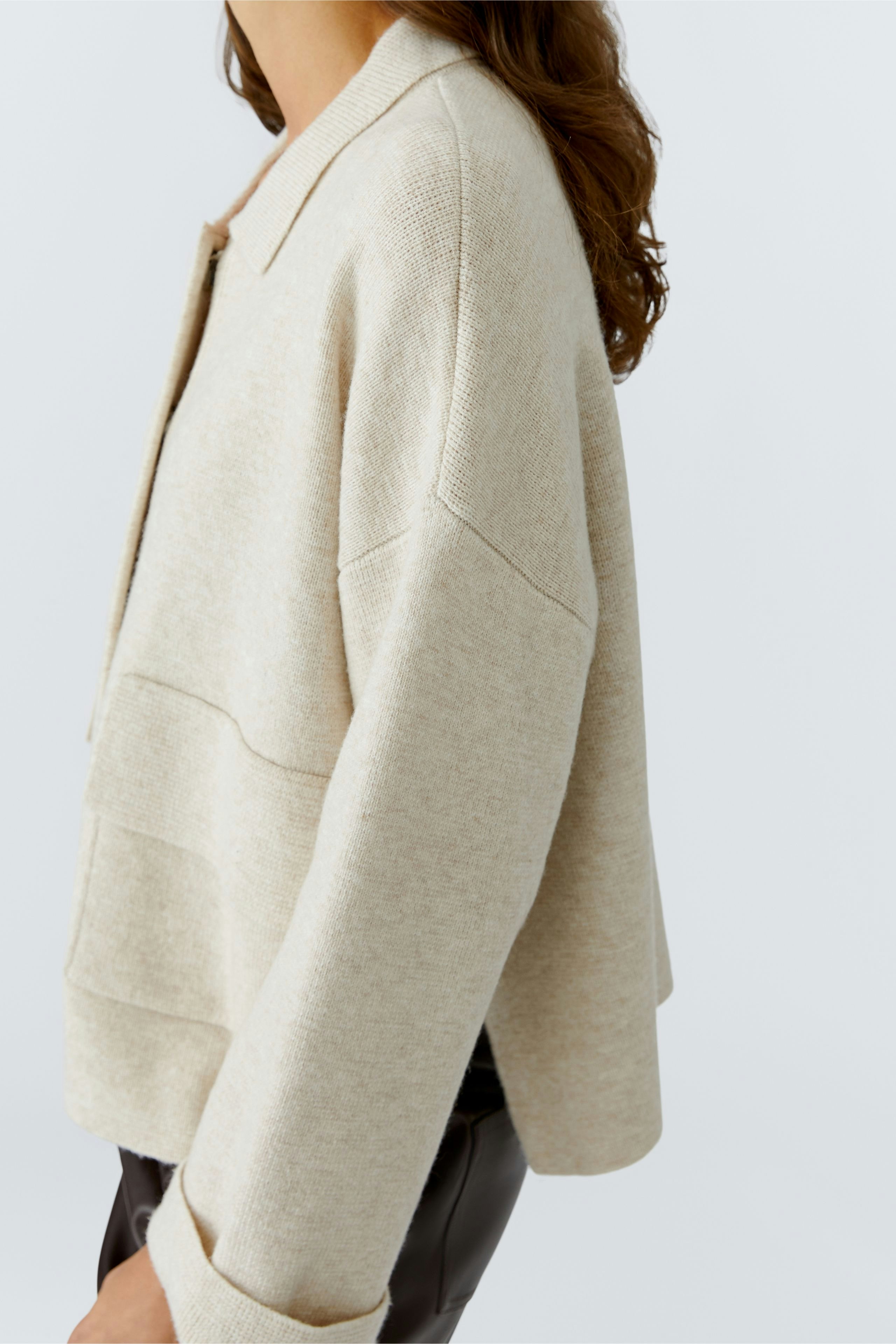 Casual women's cardigan: A woman in a light beige cardigan with a relaxed fit.