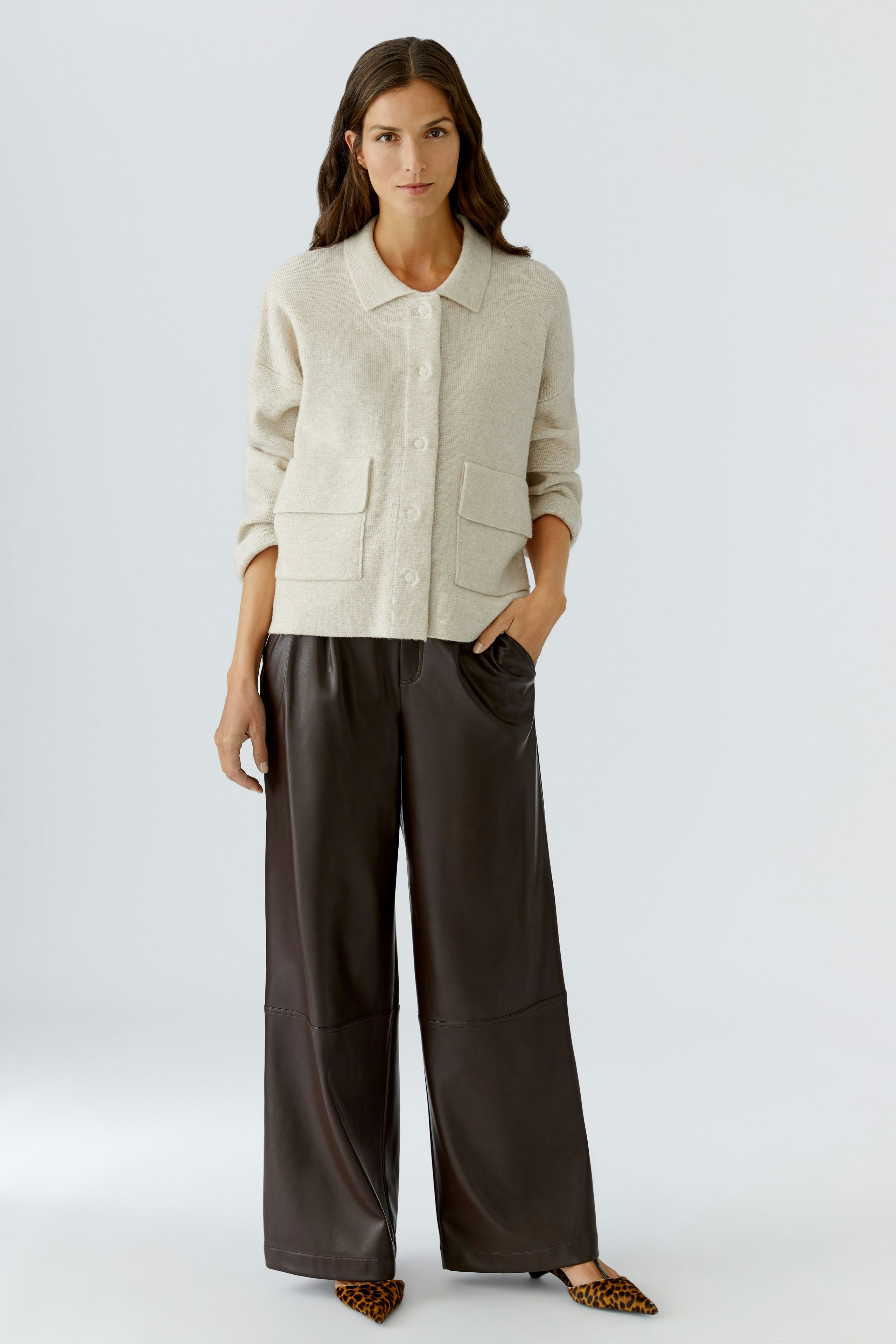 Casual women's cardigan: A woman in a light beige cardigan with pockets, paired with relaxed trousers.