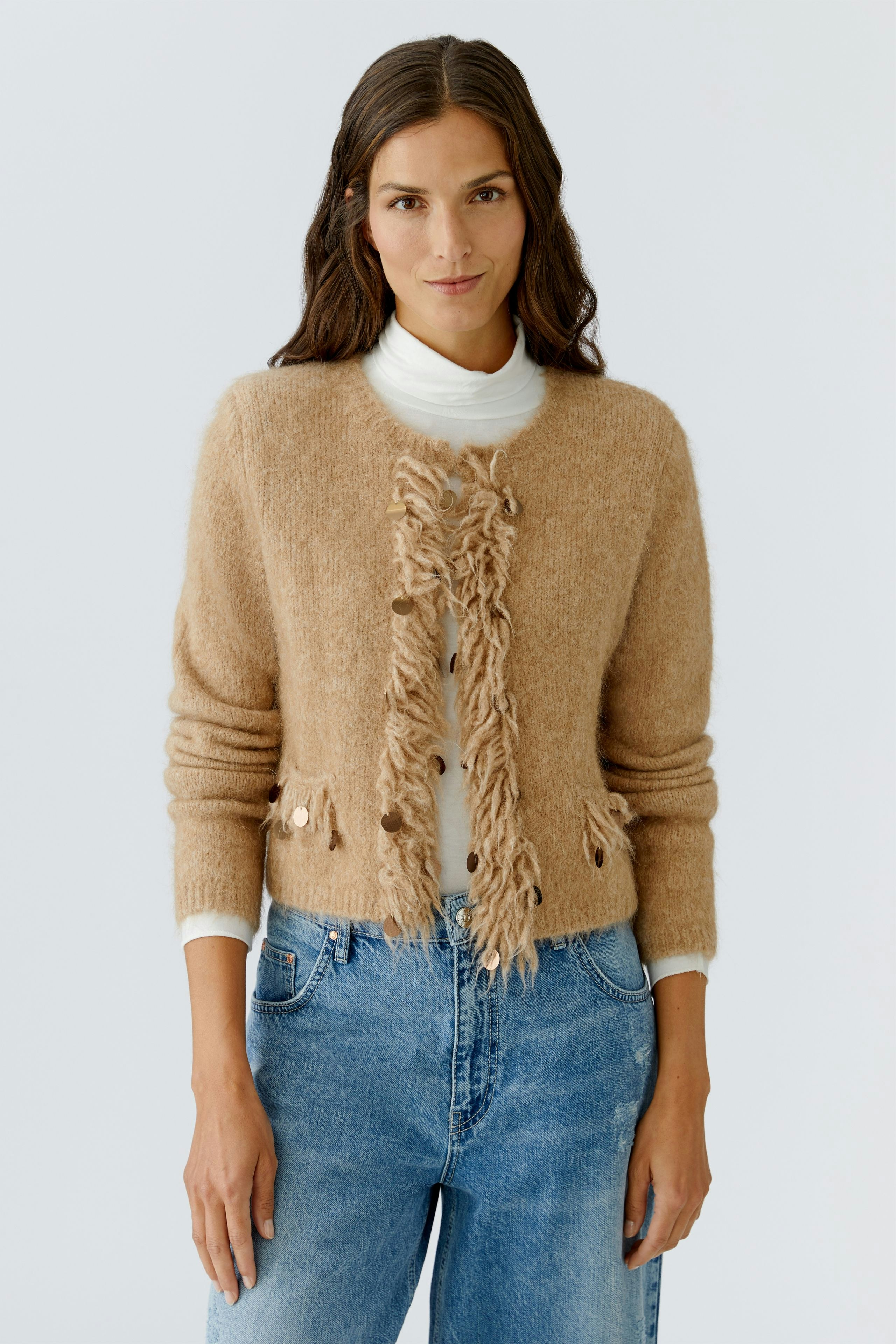 Casual women's cardigan: A woman in a soft beige cardigan with textured details and relaxed fit.