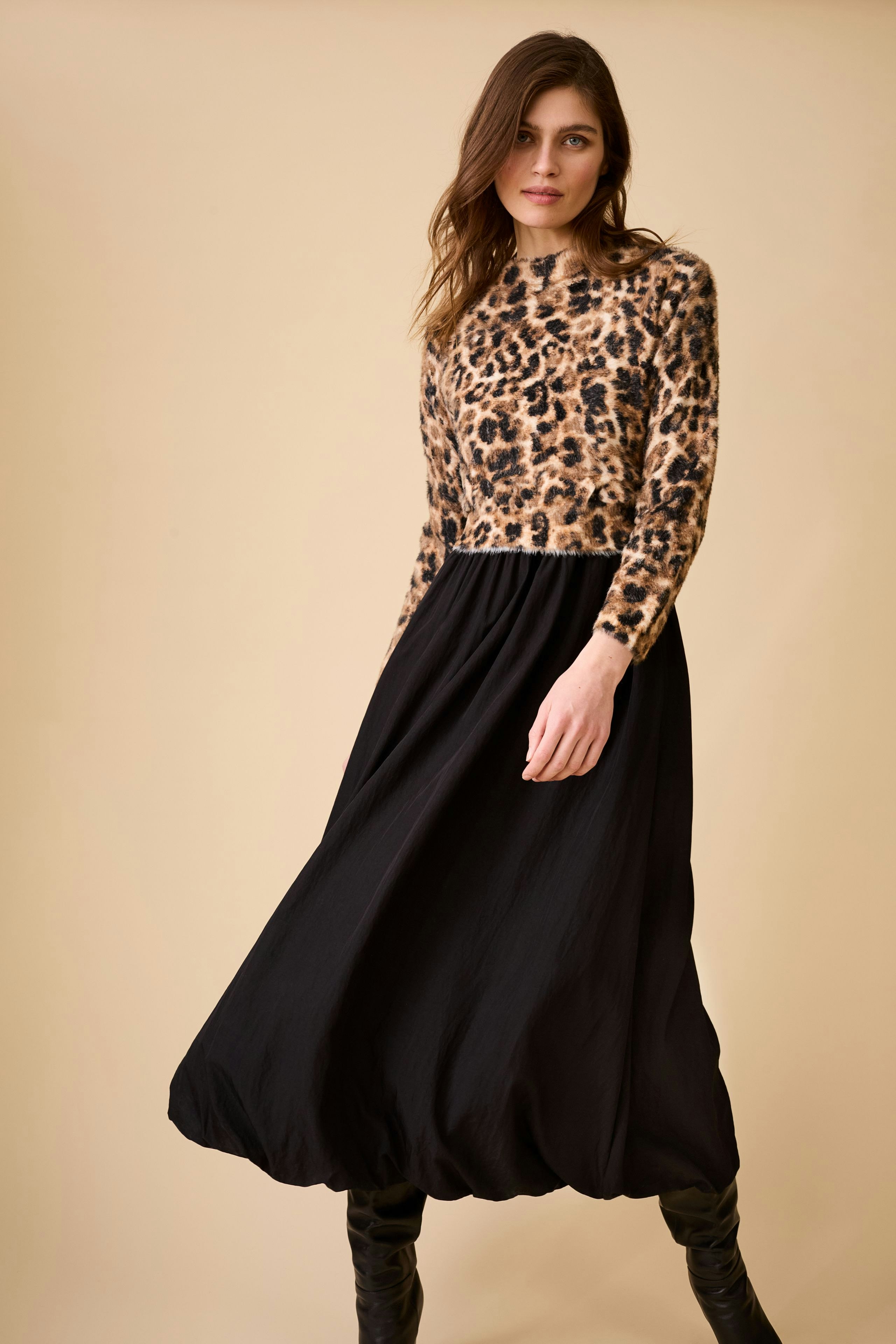 Casual midi dress: Woman in a leopard print top and black flowing skirt, showcasing a relaxed style.