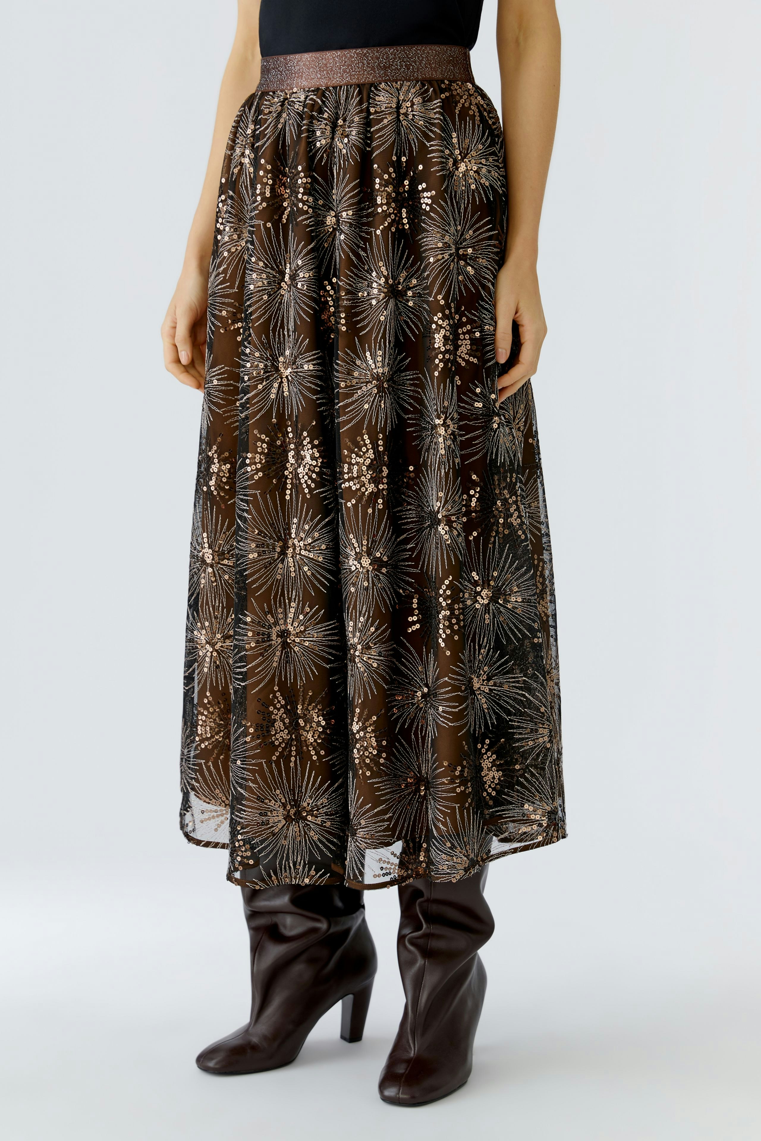 A-line skirt: Woman in a brown skirt with a floral pattern, paired with knee-high boots.