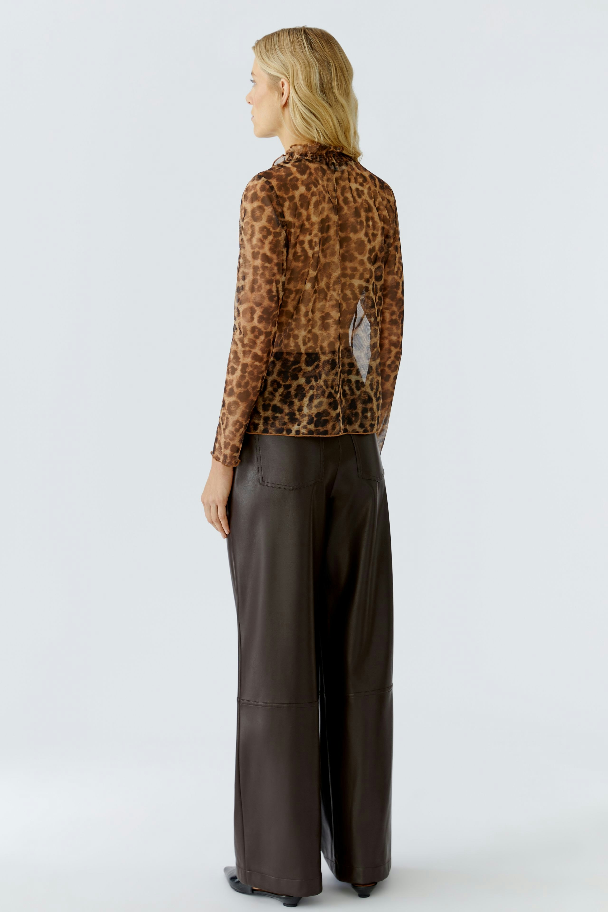 Damen Langarmshirt: Frau im braunem Shirt mit Leopardenmuster und lässigen, weiten Hosen.