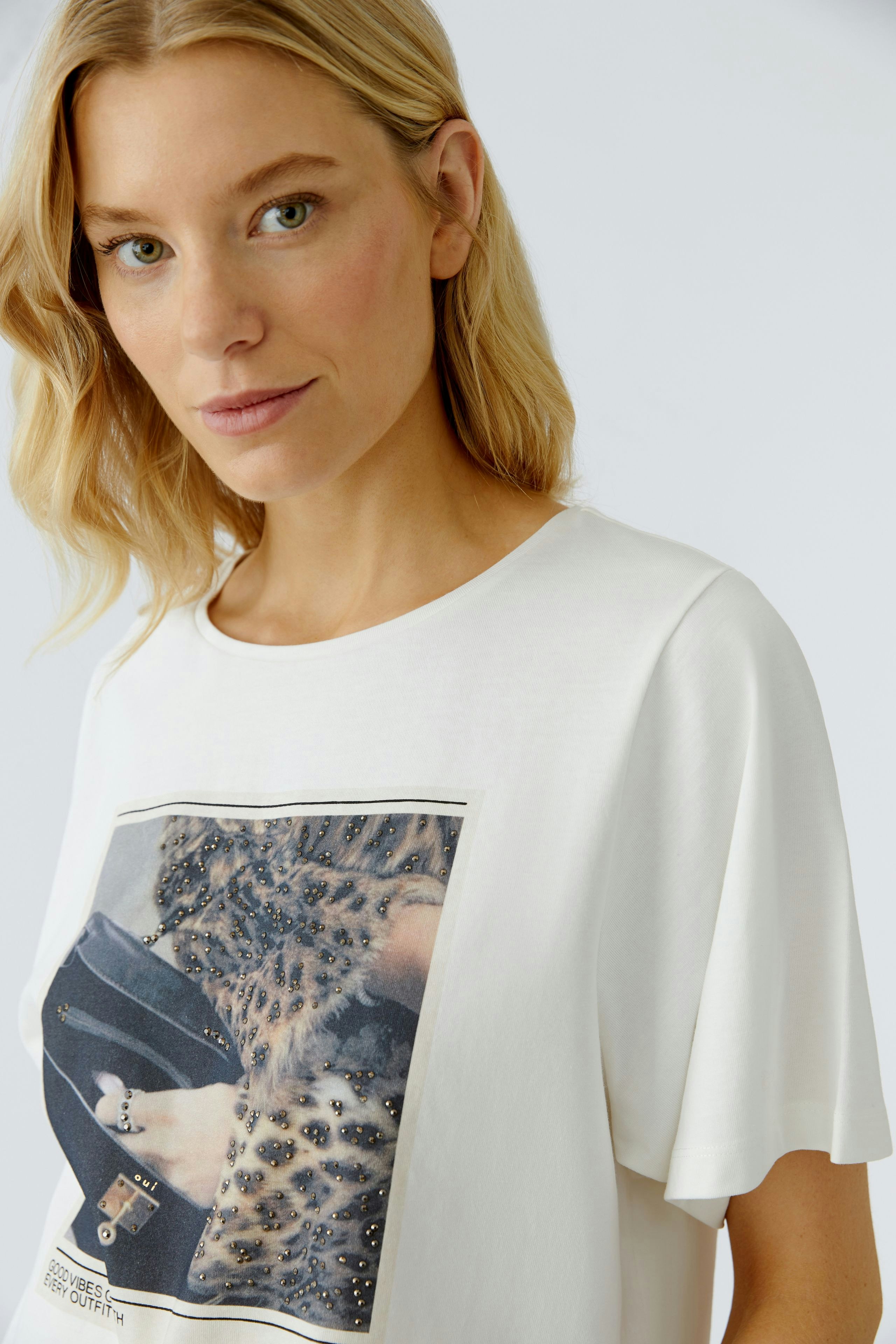 Casual women's T-shirt: Woman in a white tee featuring a stylish graphic print.