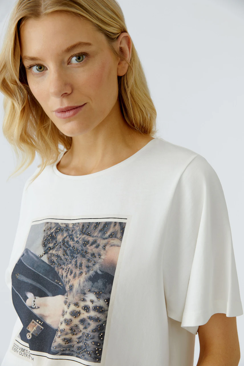 Damen-T-Shirt: Frau in weißem Shirt mit modischem Druck und lässigem Schnitt.