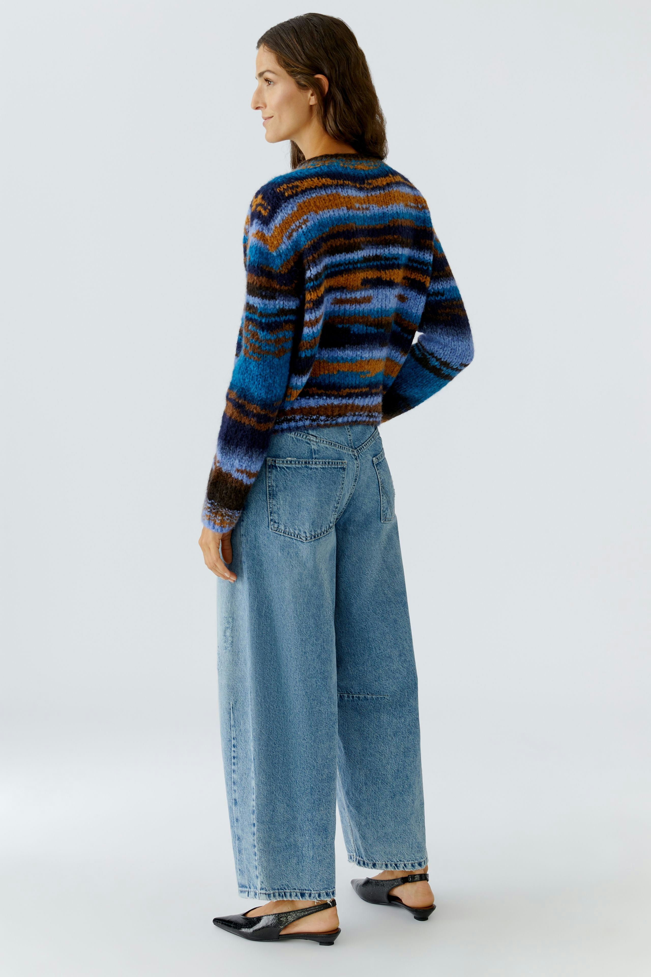 Casual women's pullover: A woman in a colorful striped pullover paired with relaxed-fit jeans.