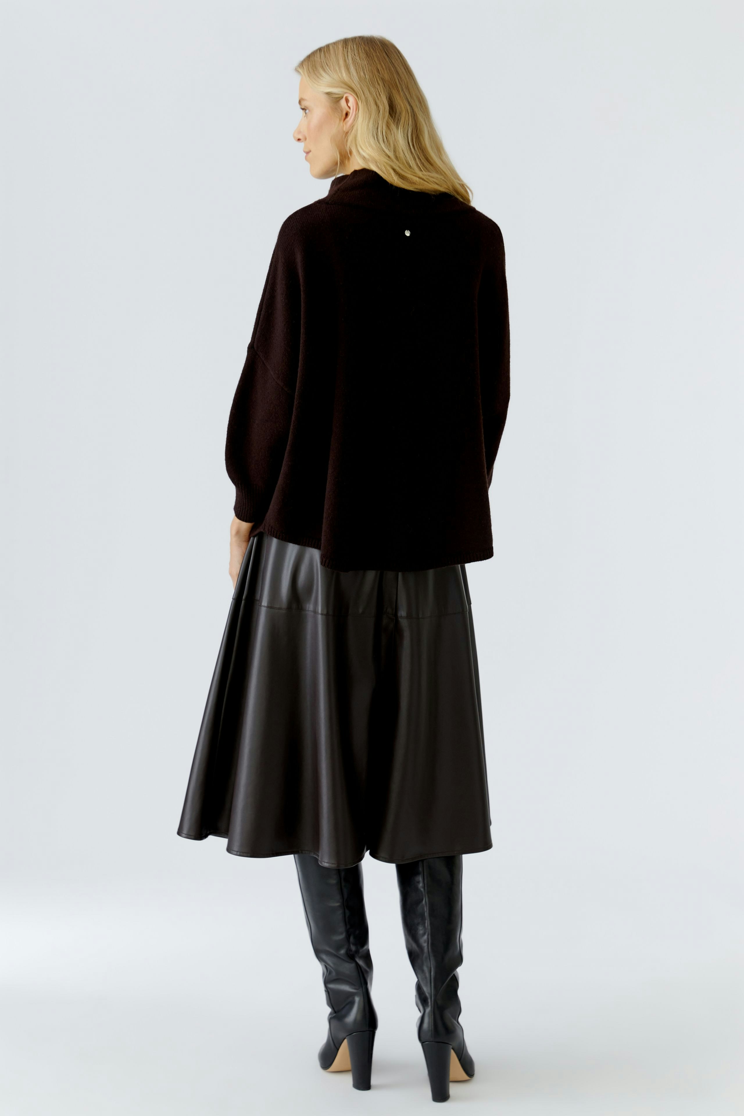 Casual women's pullover: A woman in a dark pullover with a relaxed fit, paired with a flowing skirt.