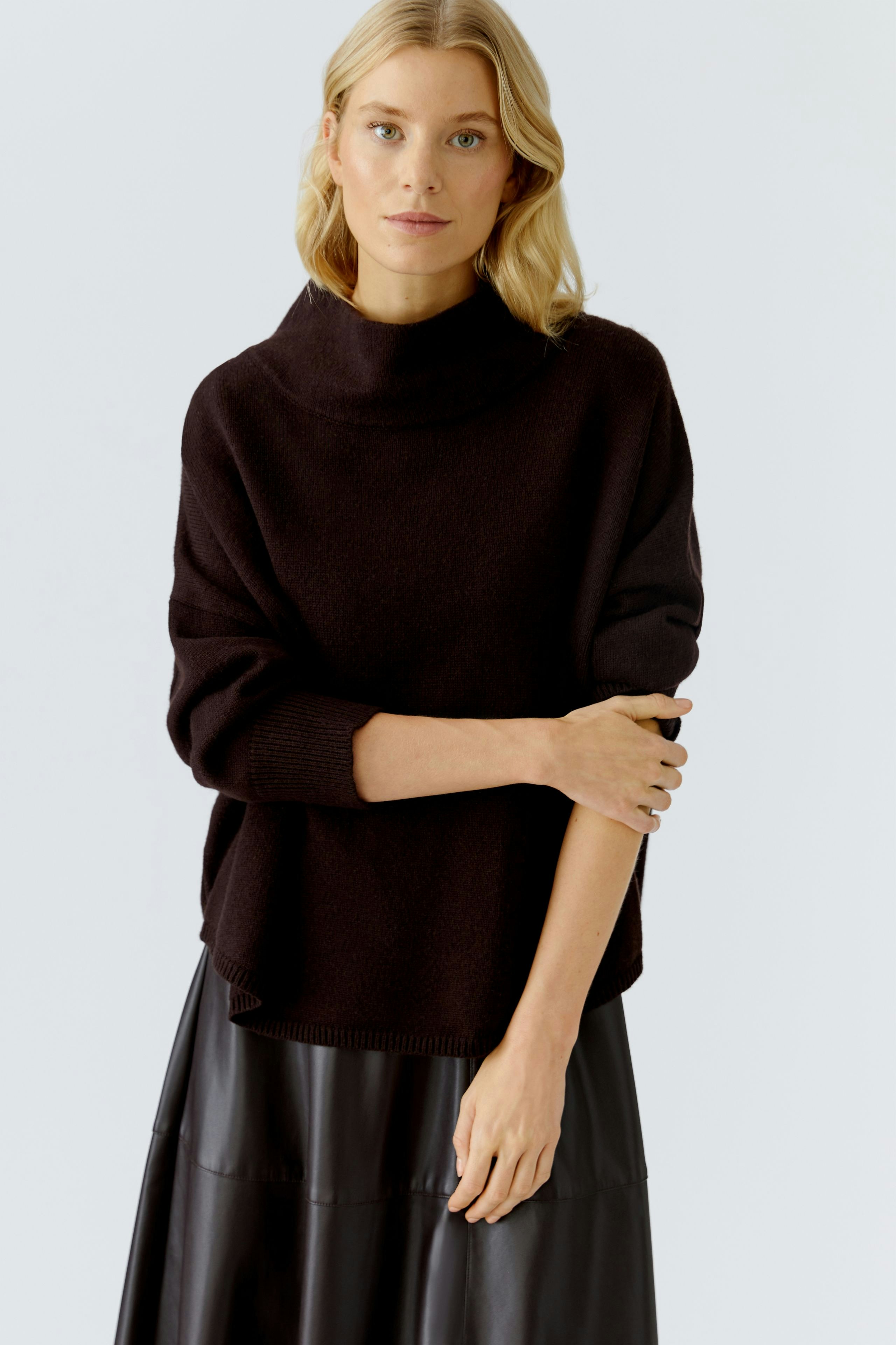 Casual women's pullover: A woman in a black oversized pullover with a relaxed fit.