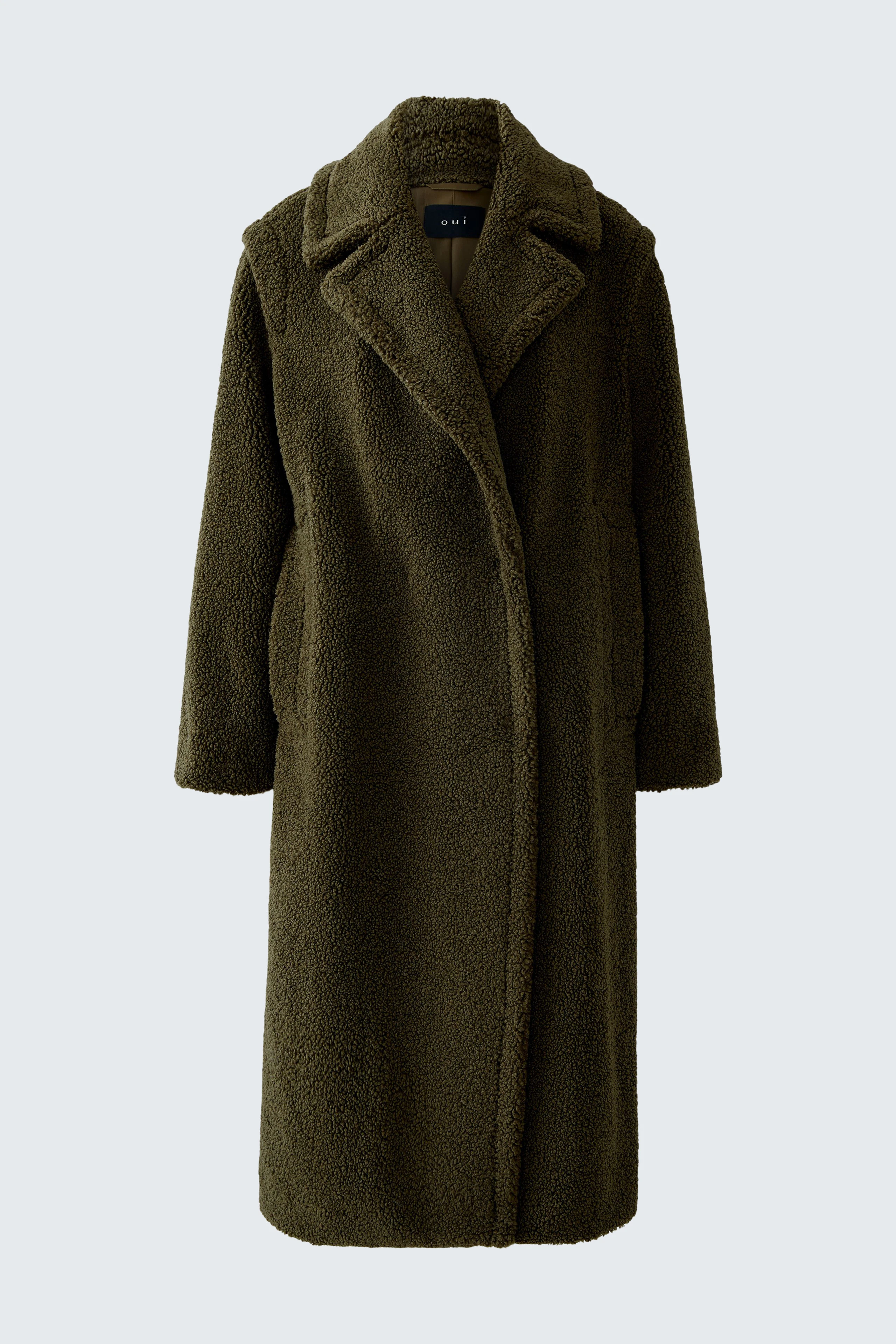 Cozy winter coat: A woman in a soft, olive green coat with a relaxed fit, perfect for chilly days.