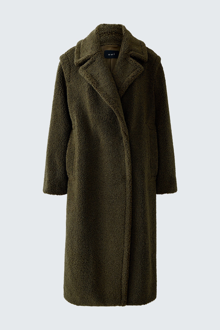 Cozy winter coat: A woman in a soft, olive green coat with a relaxed fit, perfect for chilly days.