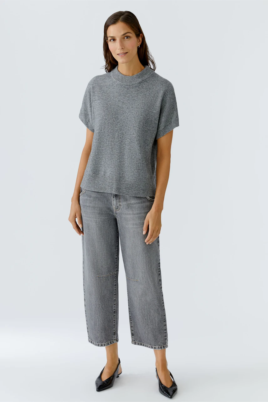 Bequemer Damen-Pullover: Frau in grauem, lässigem Pullover mit kurzen Ärmeln und lockerer Passform.