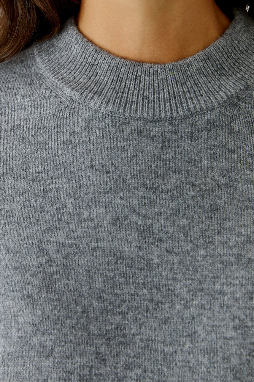 Damen-Pullover: Frau trägt einen grauen, weichen Strickpullover mit Rundhalsausschnitt.
