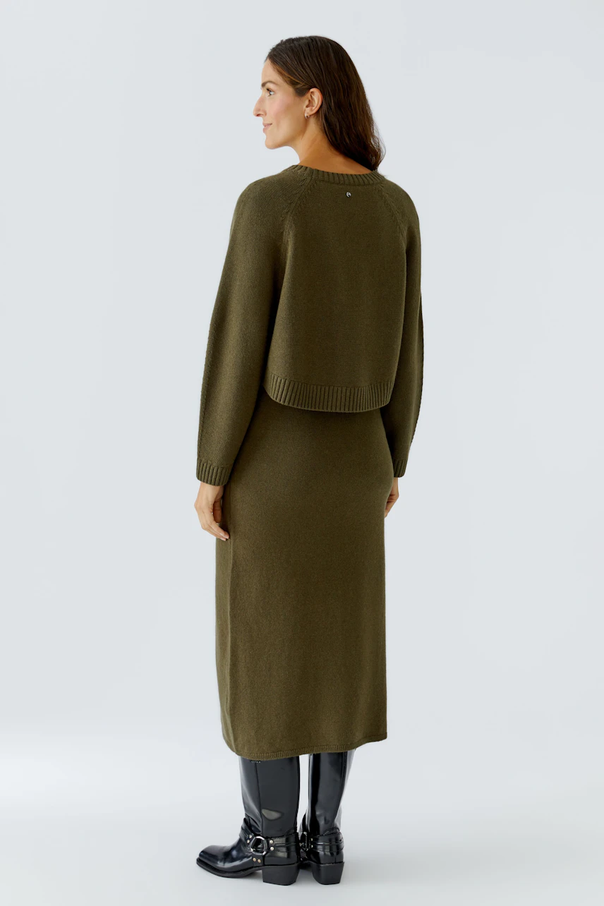 Casual women's pullover: A woman in a green pullover with a relaxed fit, showcasing a simple design.